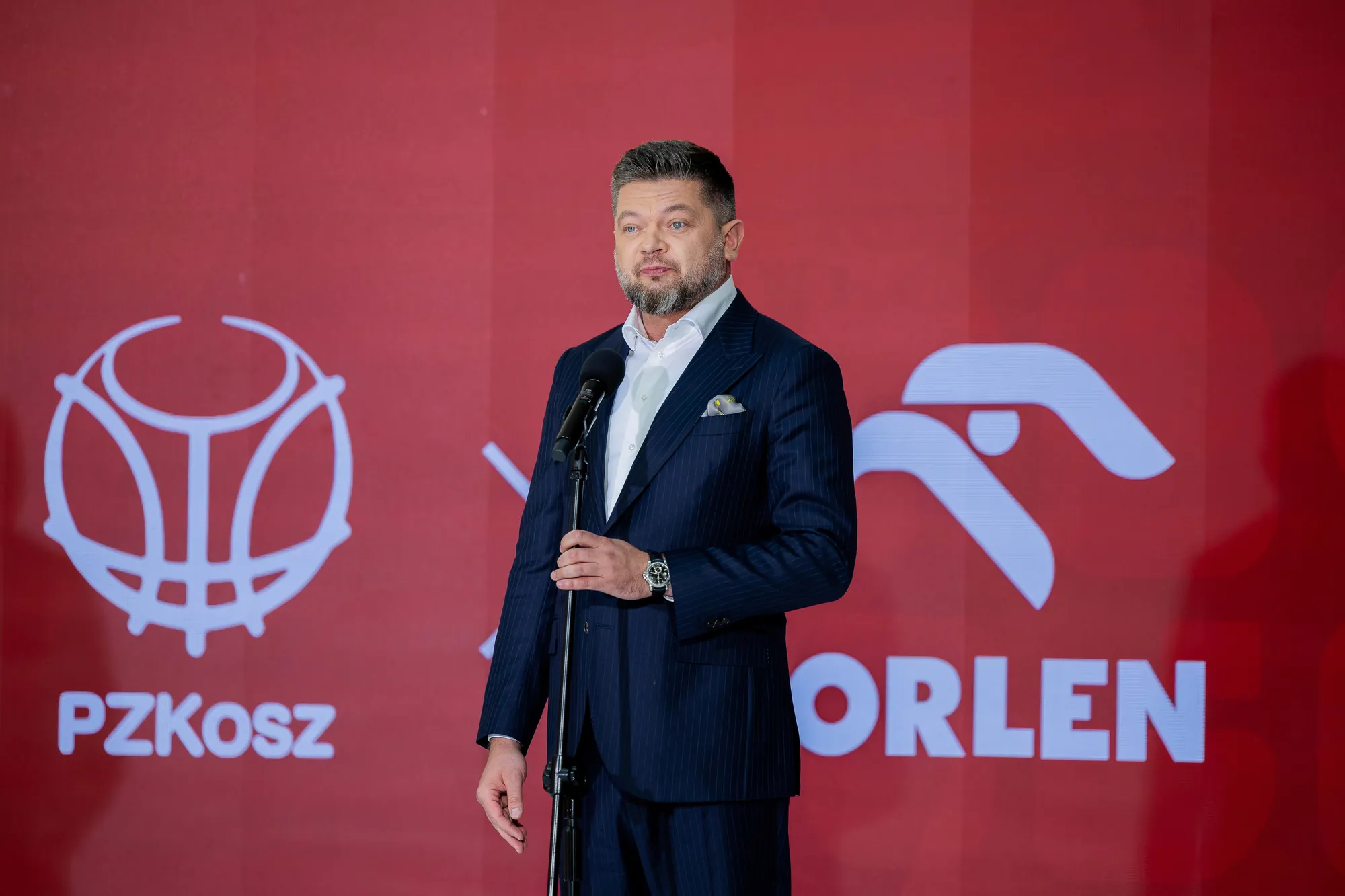 PZKosz i ORLEN – przemówienie podczas konferencji prasowej na tle logotypów partnerów.