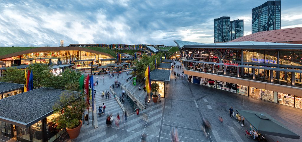 Restored brick building with arched windows and modern glass storefront on a quiet street