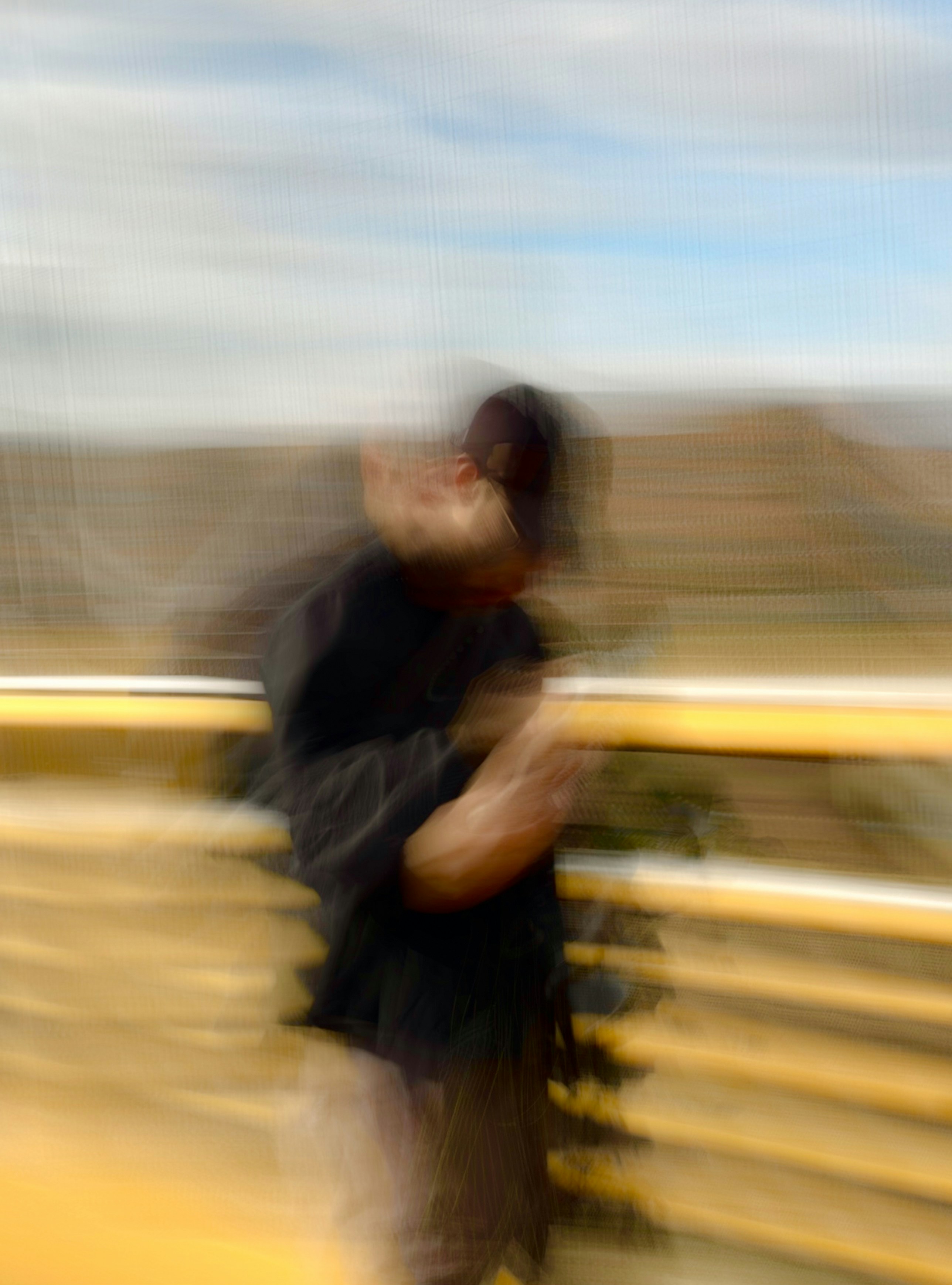 A blurry photo of a man standing on a bridge