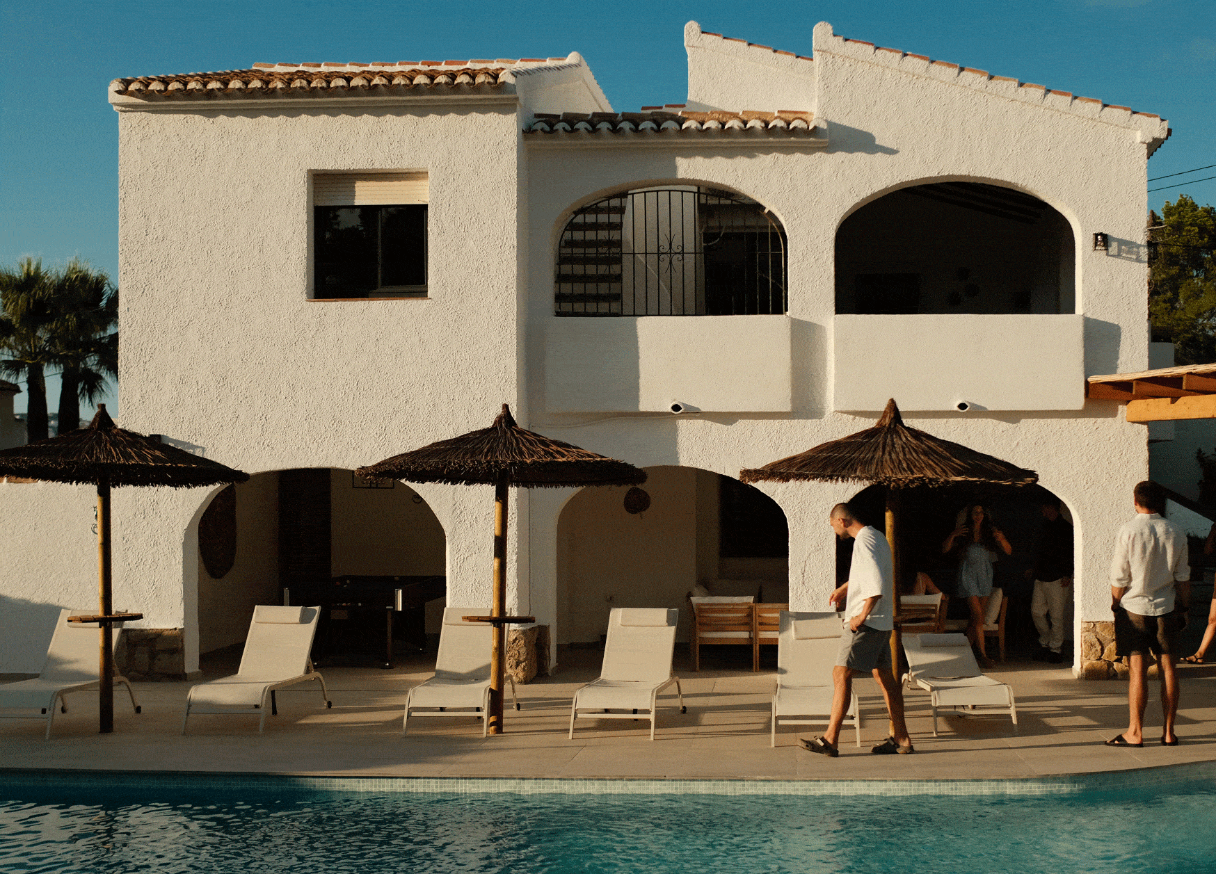 Four diverse professionals collaboratively working on a laptop, with one person pointing at the screen while others observe.