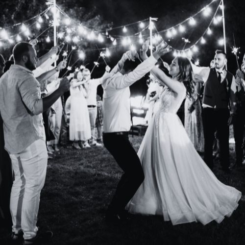 Guests enjoying the wedding celebration, dancing joyfully under vibrant, changing lights that fill the room with excitement and energy.