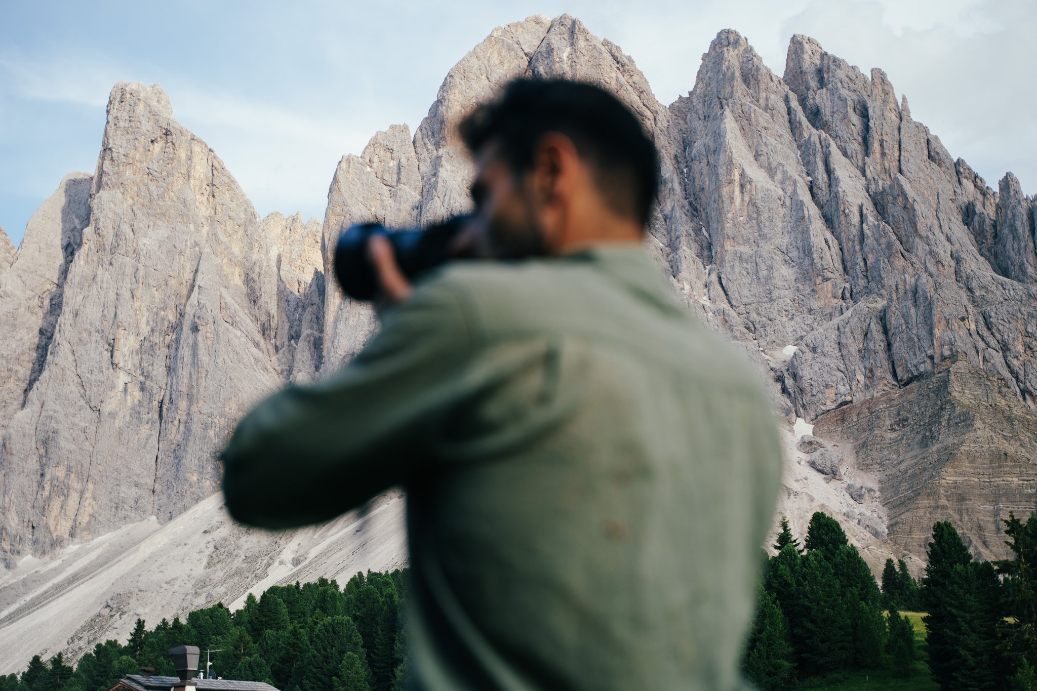 adventure filmaker holding a camera in dolomites mountains