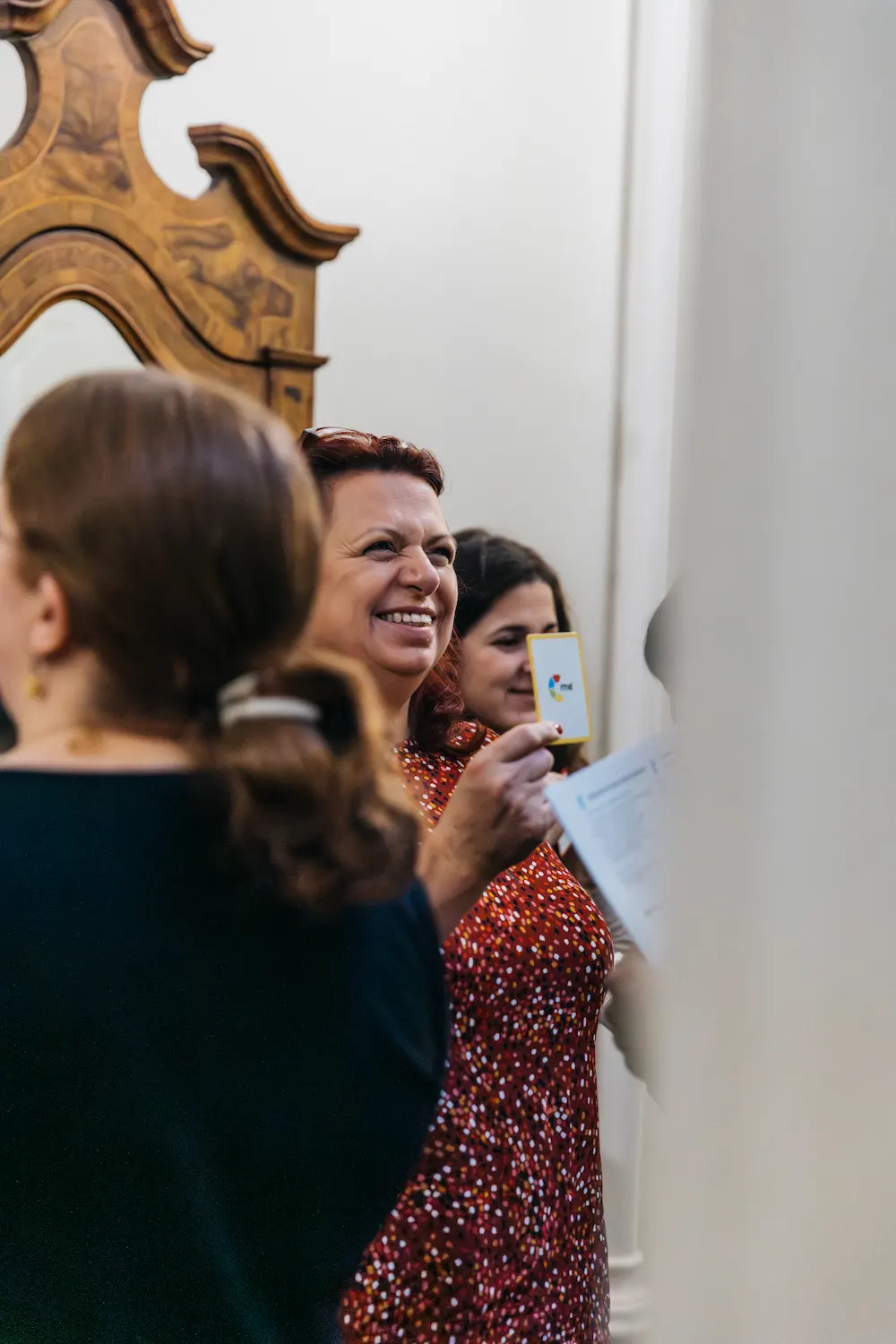 People taking photos of a mirror with another person behind.