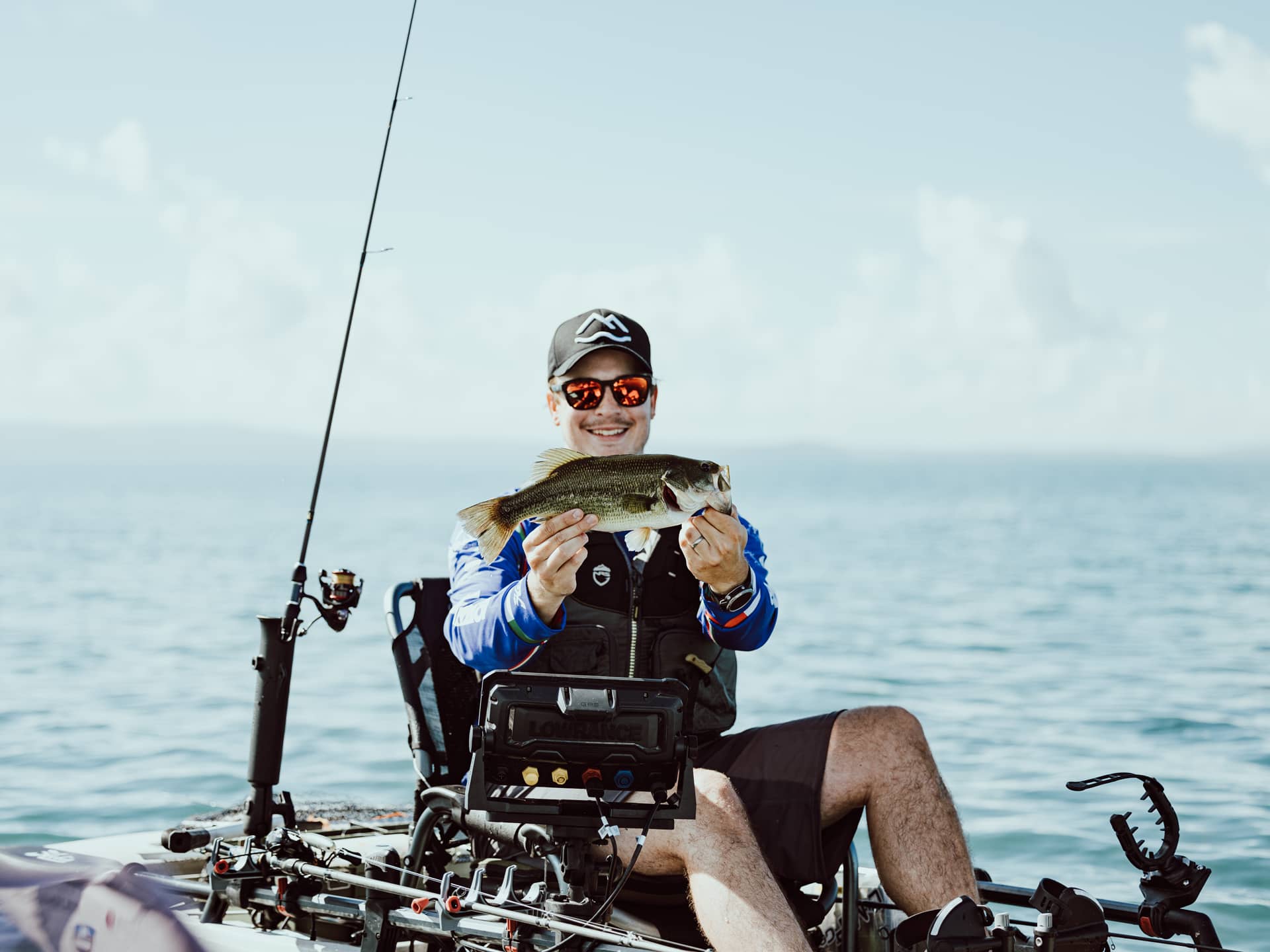 Person som stolt håller upp sin fångst på en kajak