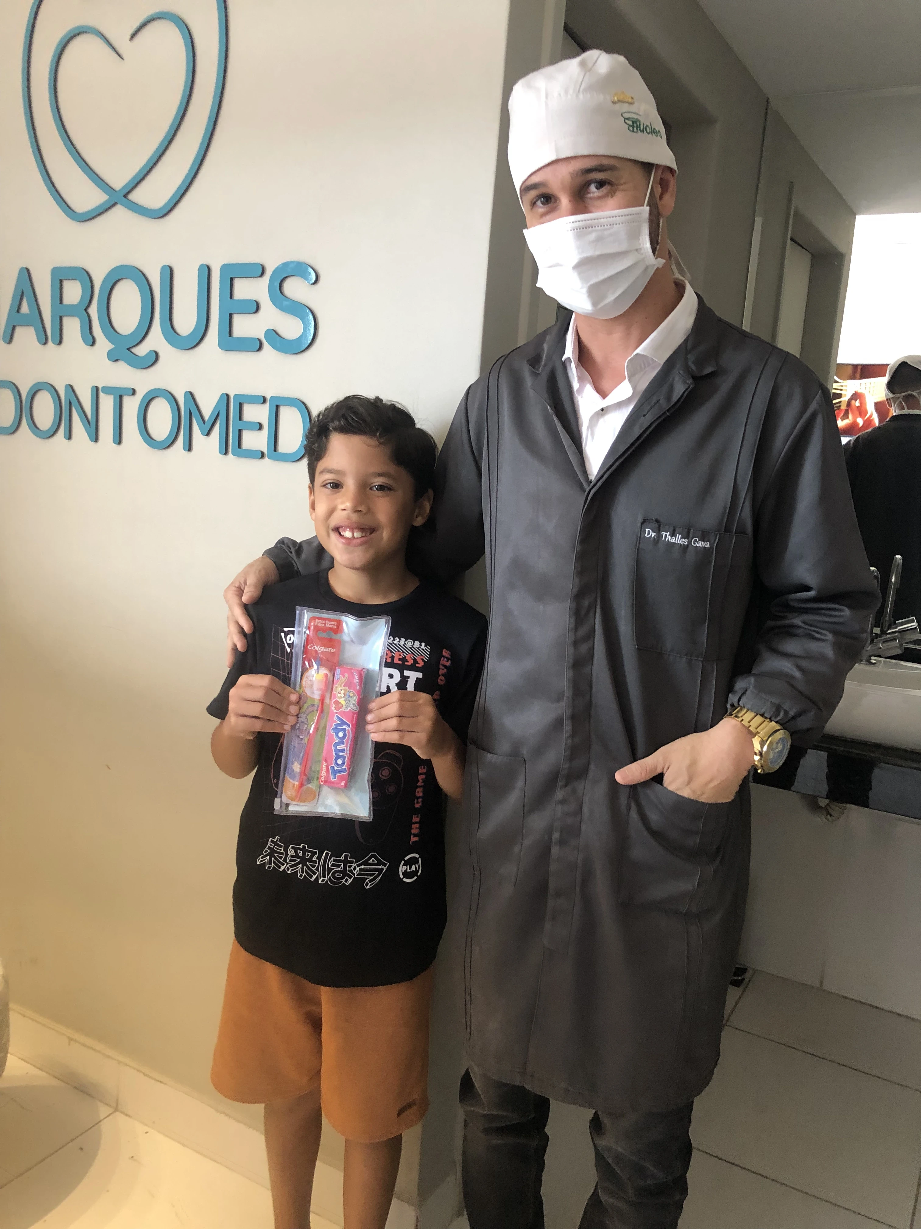 Dentista Thalles avaliando o sorriso de uma paciente criança.