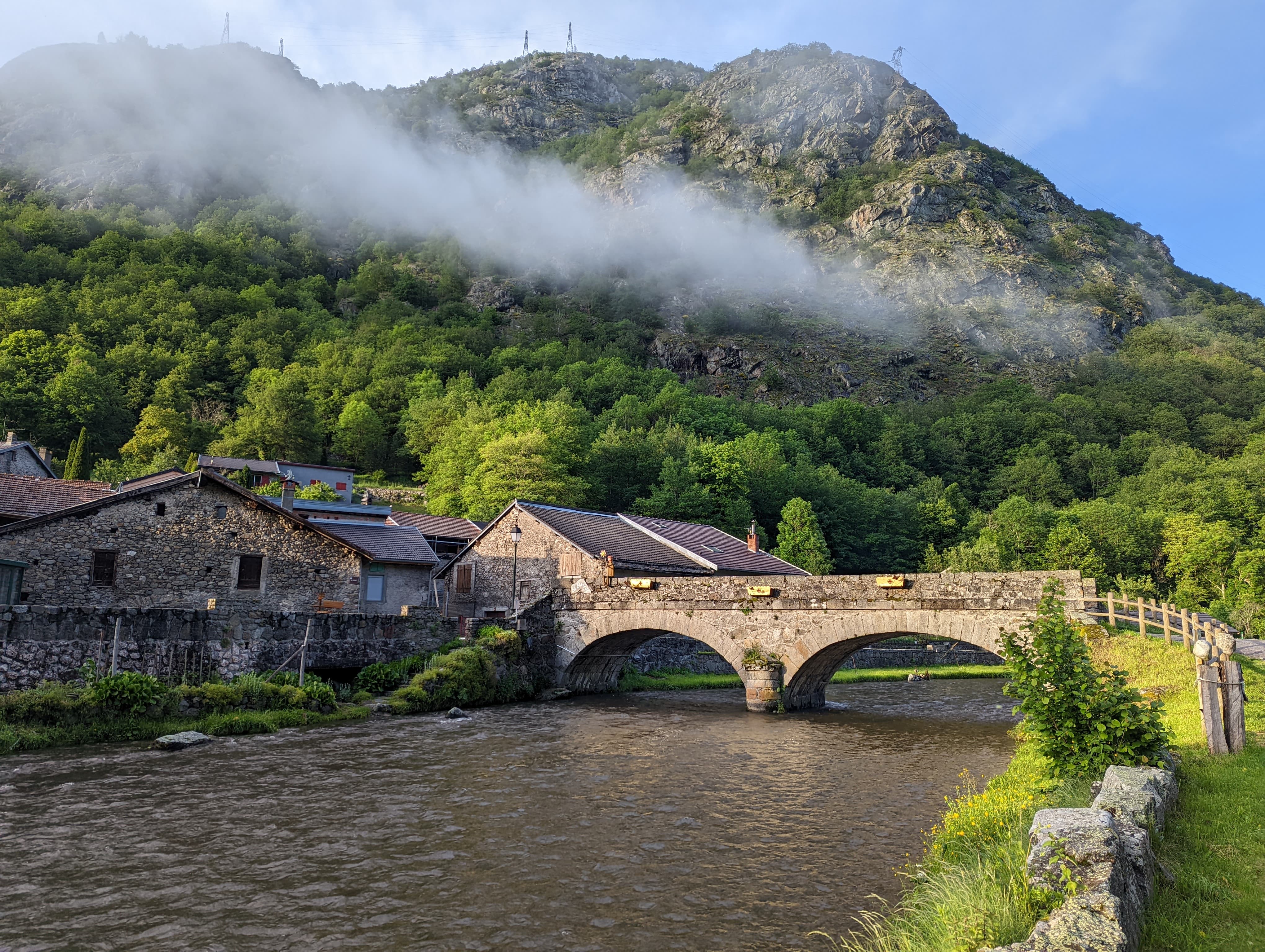 Ariège fly fishing: an angler with a large trout in a picturesque Pyrenean setting.