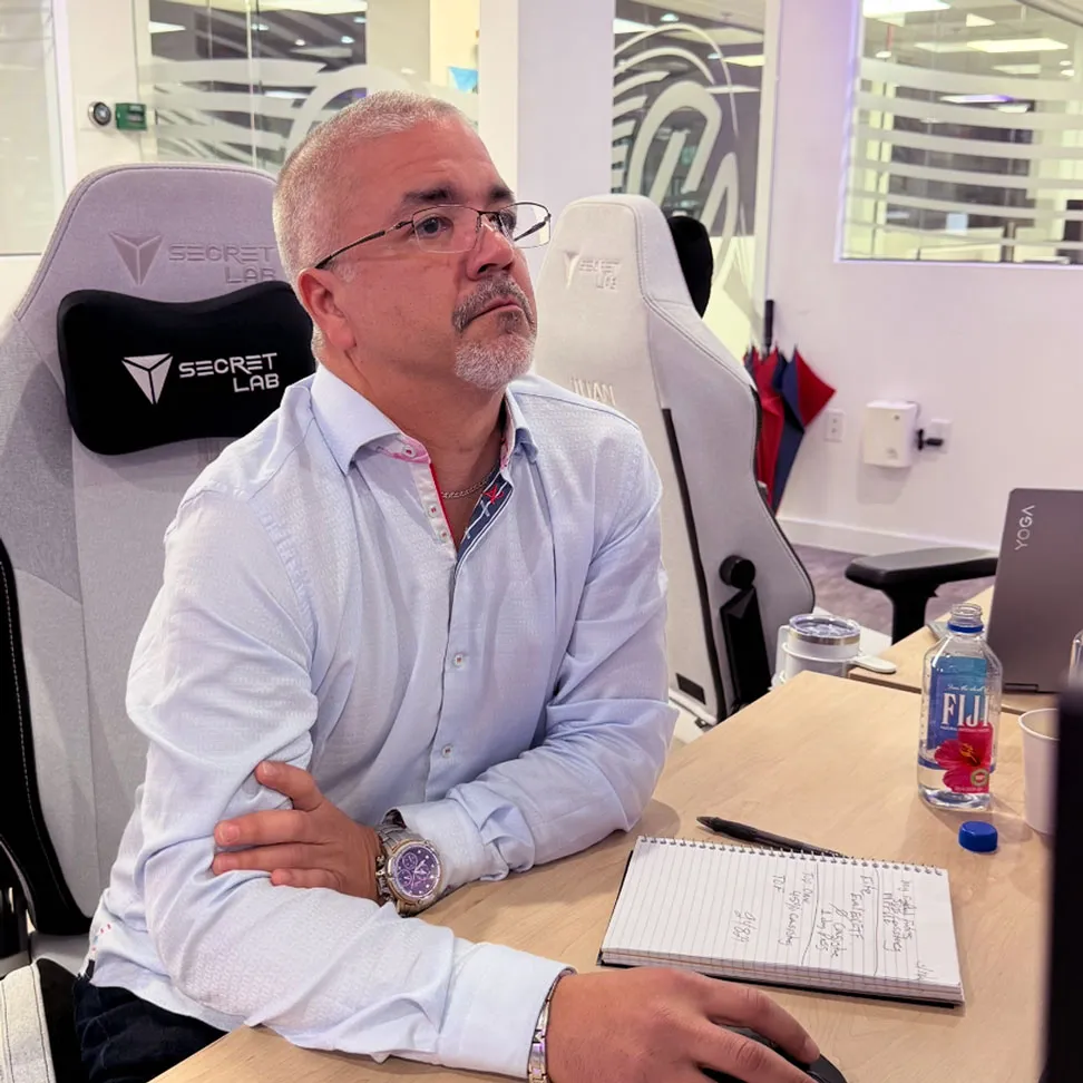 Hombre atento trabajando en su computadora desde las oficinas de Highway Trading Academy.