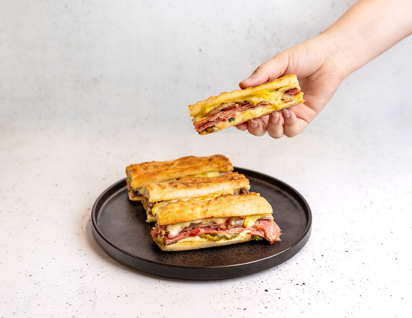 Cuban Sandwich with honey leg ham, smoked mojo pork, pickles, mustard & Swiss cheese on a toasted baguette