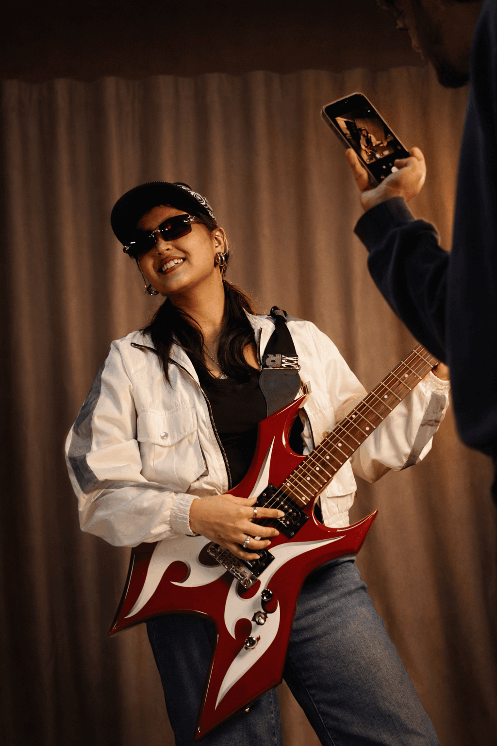 A man with voluminous curly hair and a leather jacket at a party