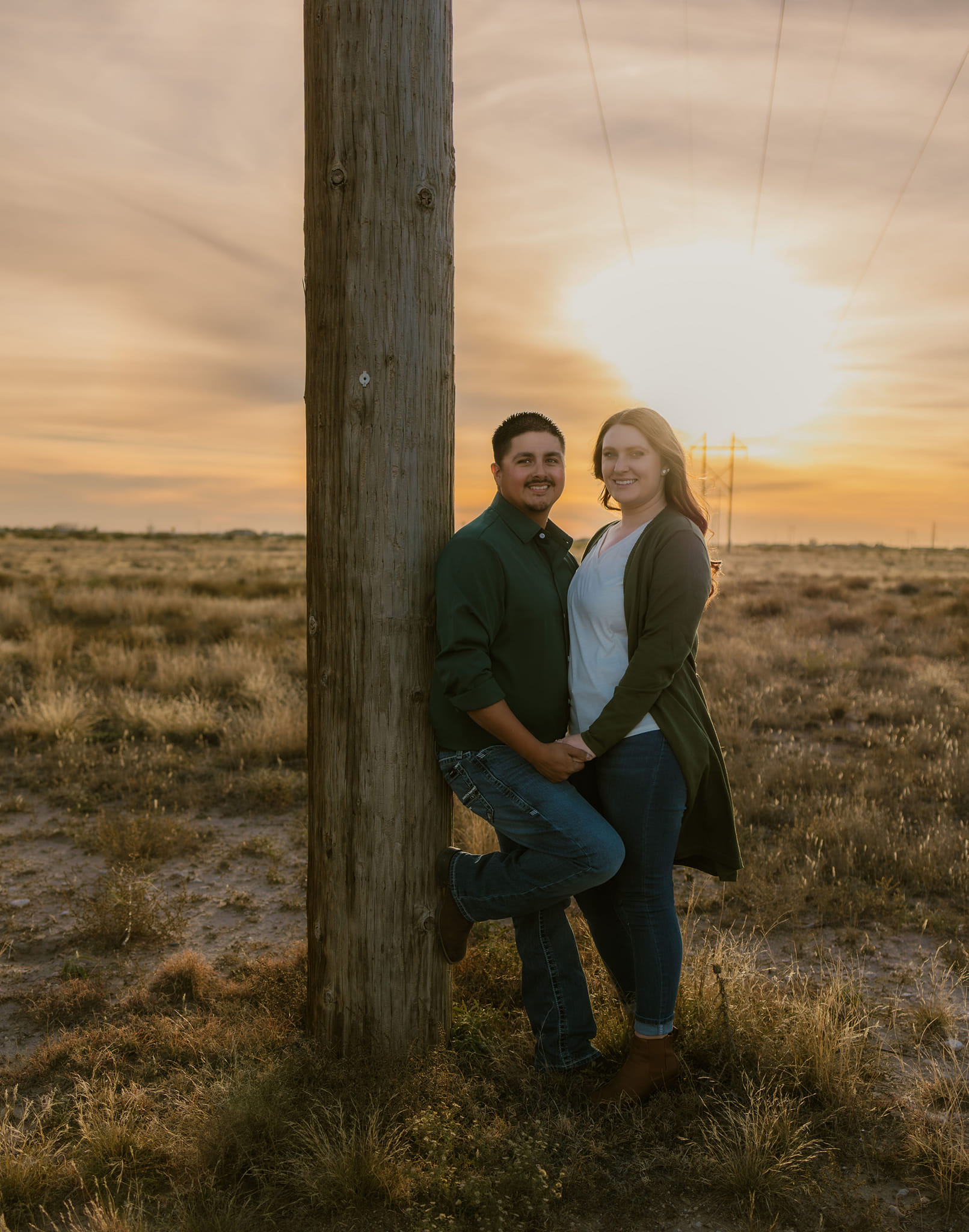 A bride and groom share a kiss surrounded by a joyful bridal party.