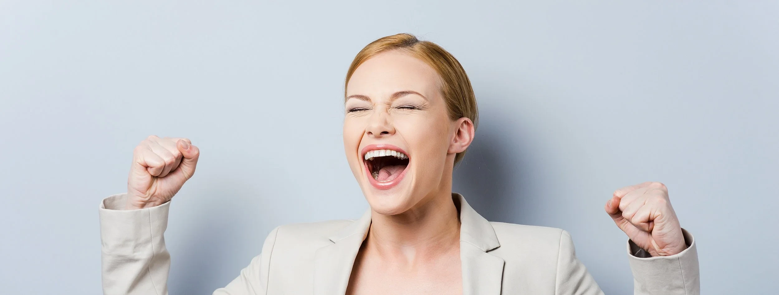 Woman cheering against a wall