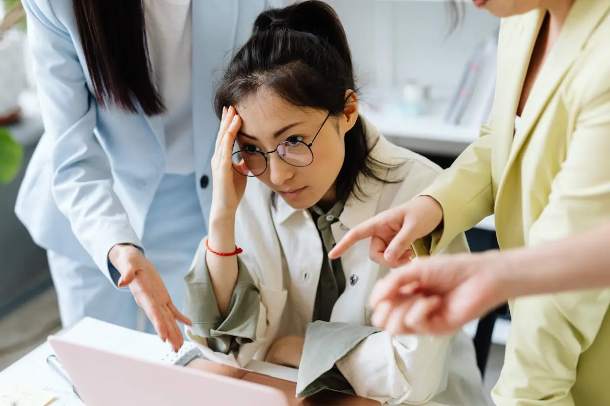 3 people pointing at each other and looking frustrated