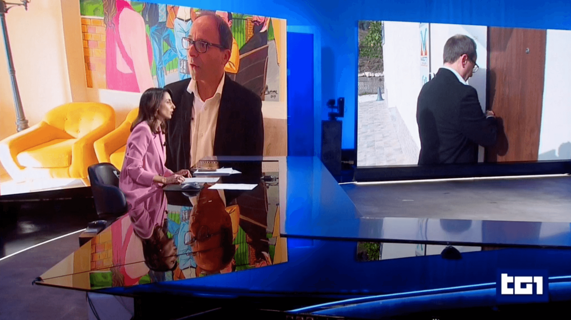 A man in a white lab coat working at a computer, viewing a 3D model on the screen in a laboratory or office setting.