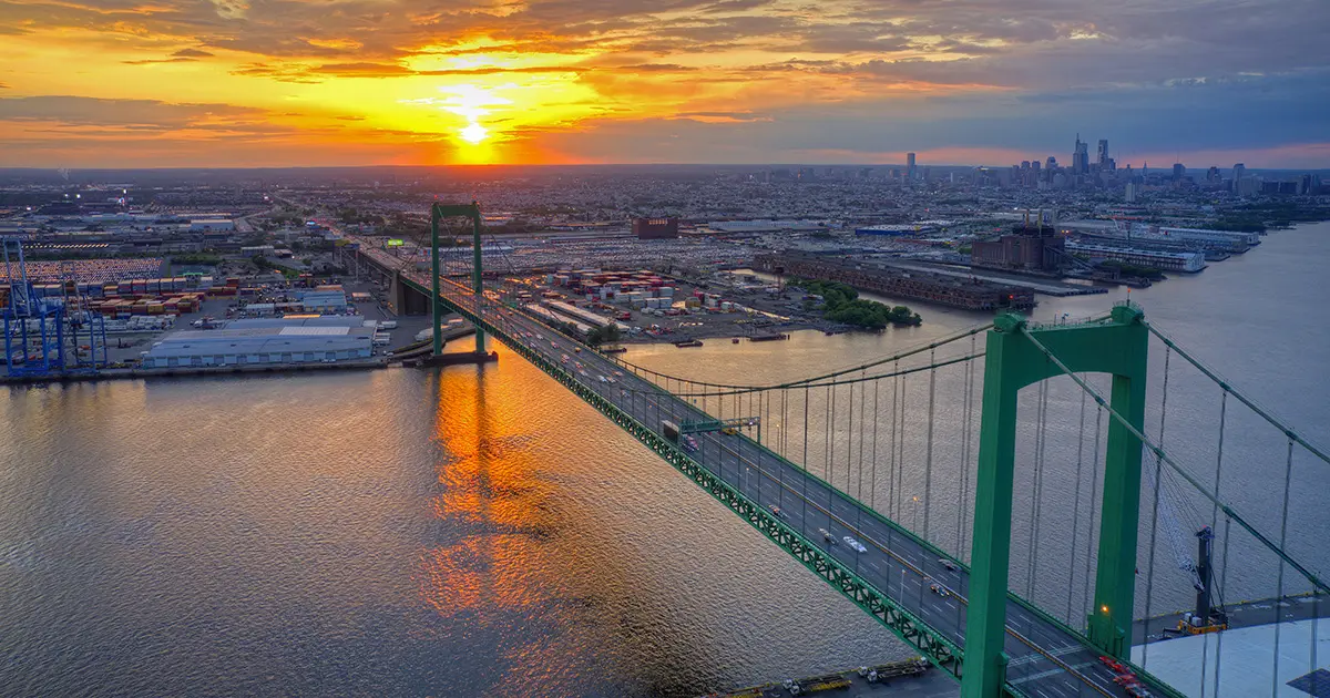 Aerial view of the Walt Whitman Bridge at sunset with the Philadelphia skyline in the distance
