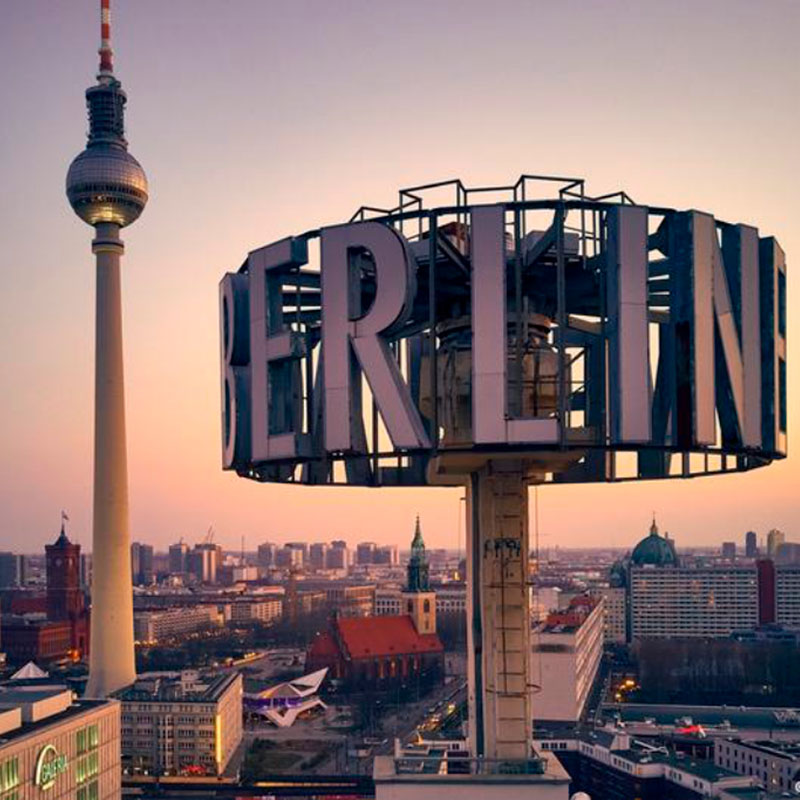 New York City skyline at twilight featuring the Empire State Building and other skyscrapers illuminated against a purple-blue sky.