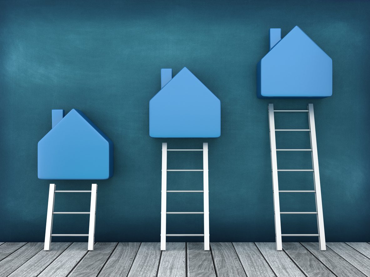Blue houses on ladders ascending in size.