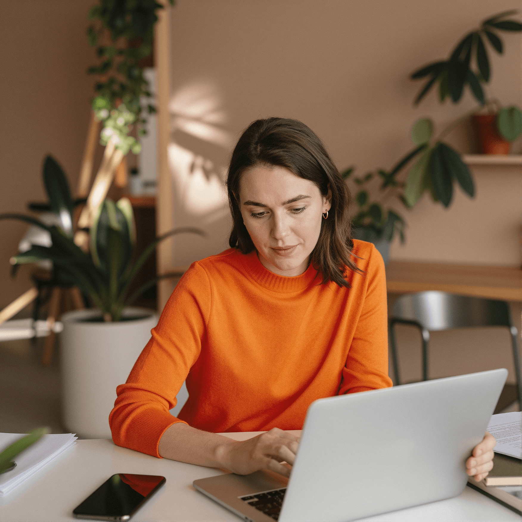 Smiling young man with short hair poses against a dark background, wearing a green button-up shirt.