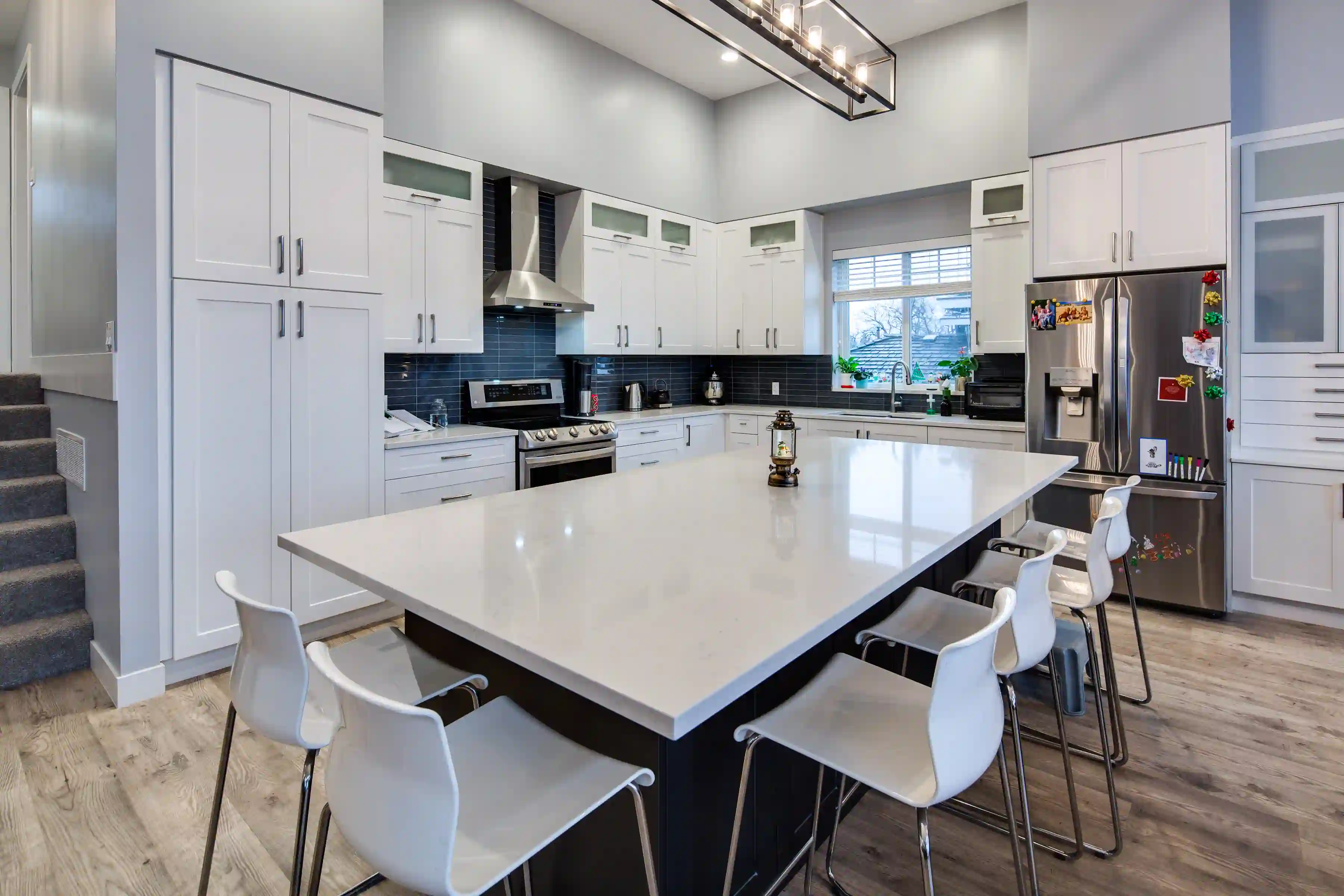 Open concept kitchen and living area inside a finished custom home with modern finishes and natural light