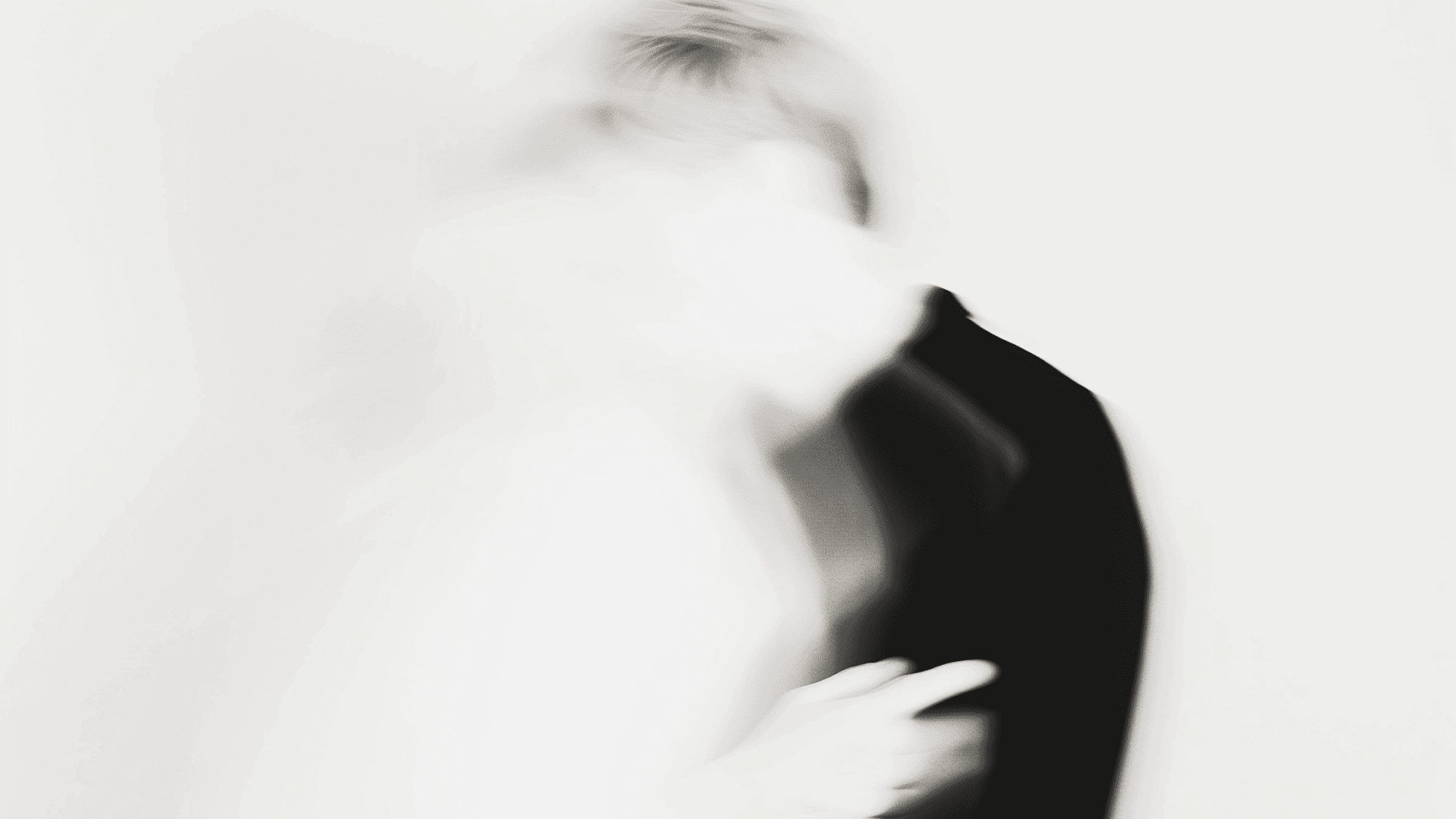 Abstract blurred image of a human figure in motion, with contrasting black and white tones creating a ghostly, ethereal effect.