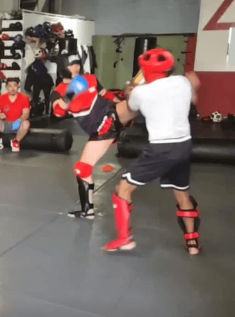 Two fighters sparring in full gear at Satori Fight Club