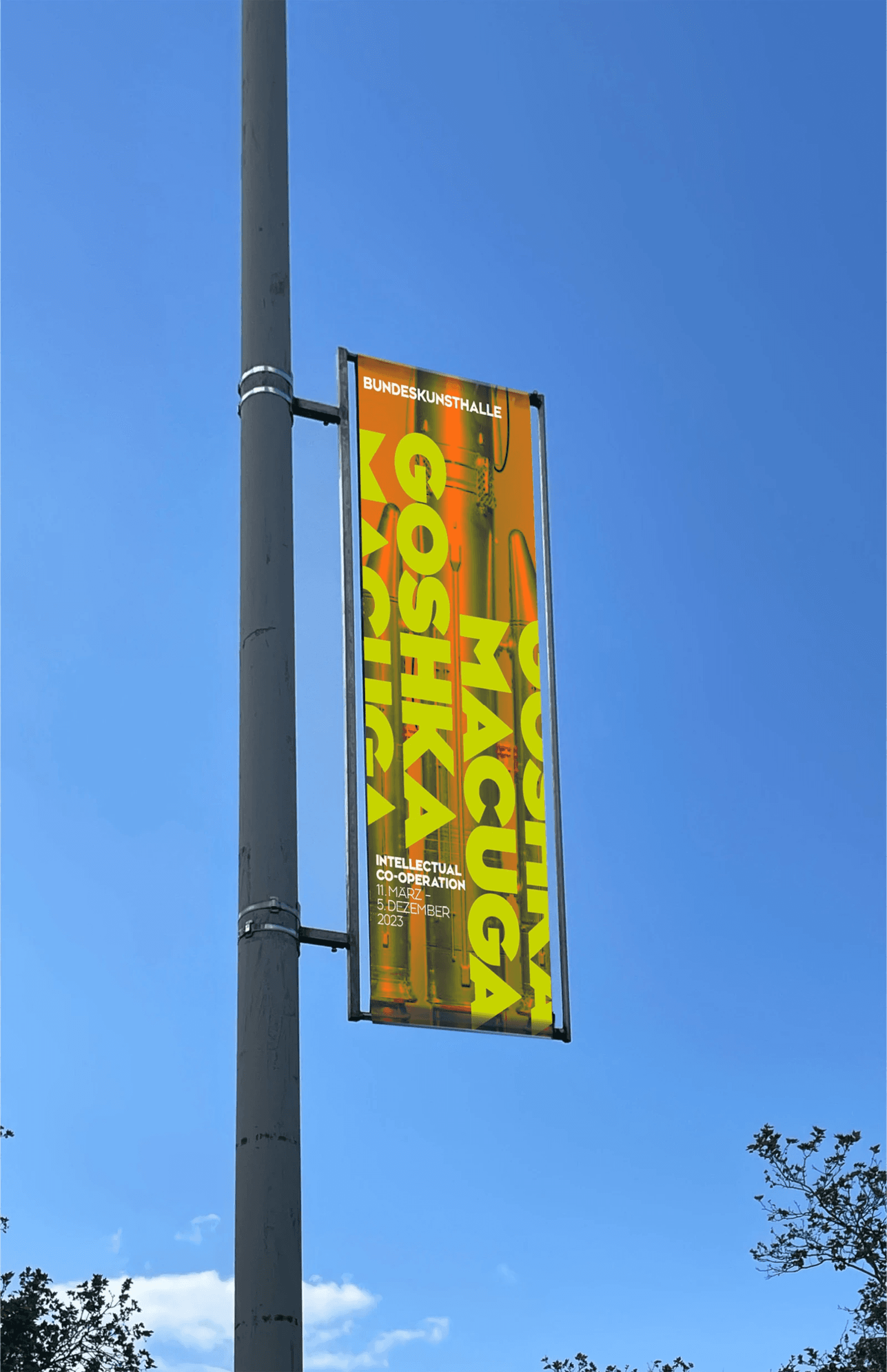 A colorful banner on a pole against a clear blue sky, promoting an event or service.