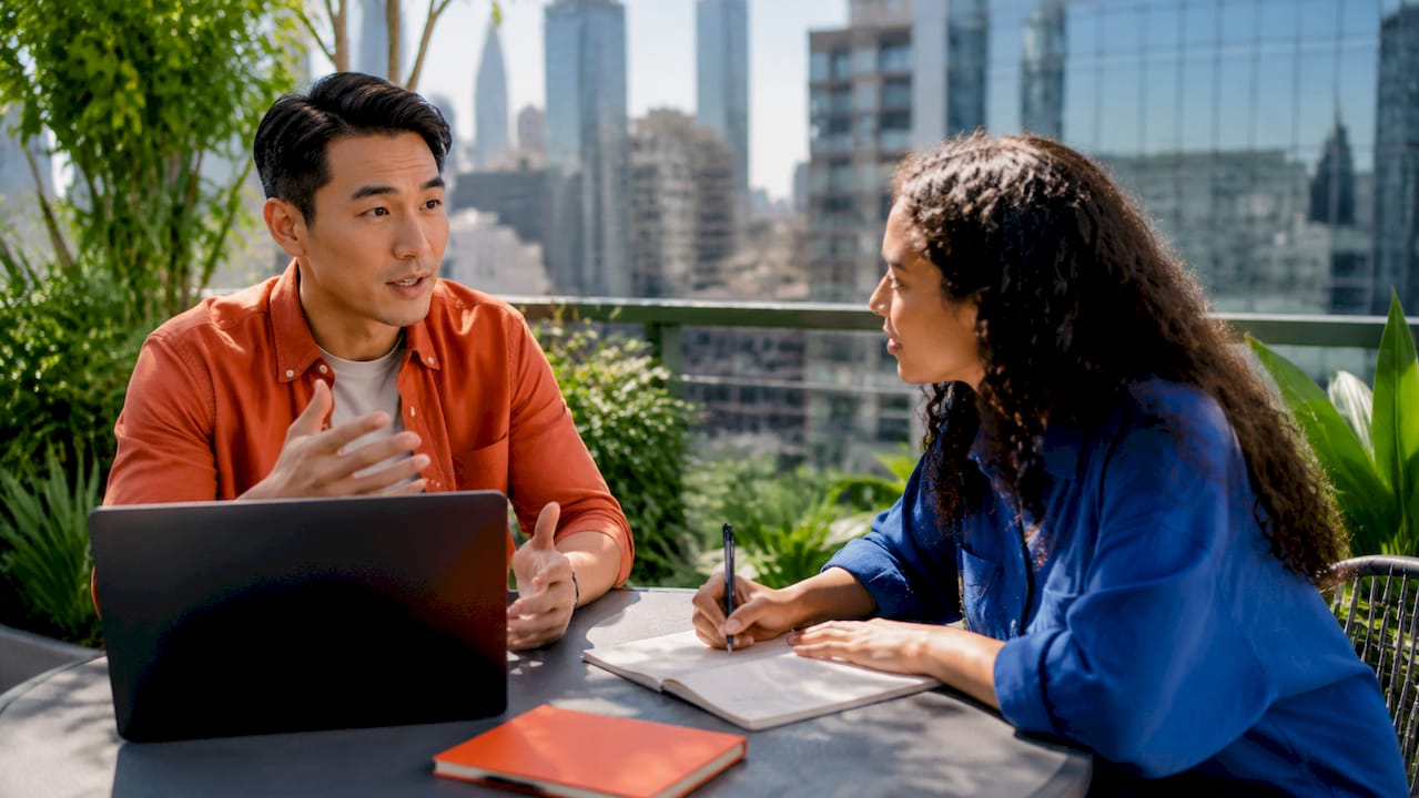 Two translators discussing client project in meeting room