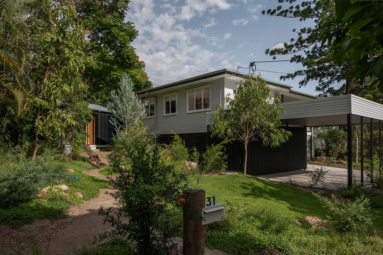 Toohey Forest House exterior showing retained post-war home and contemporary pavilion set within a native garden landscape in Brisbane.