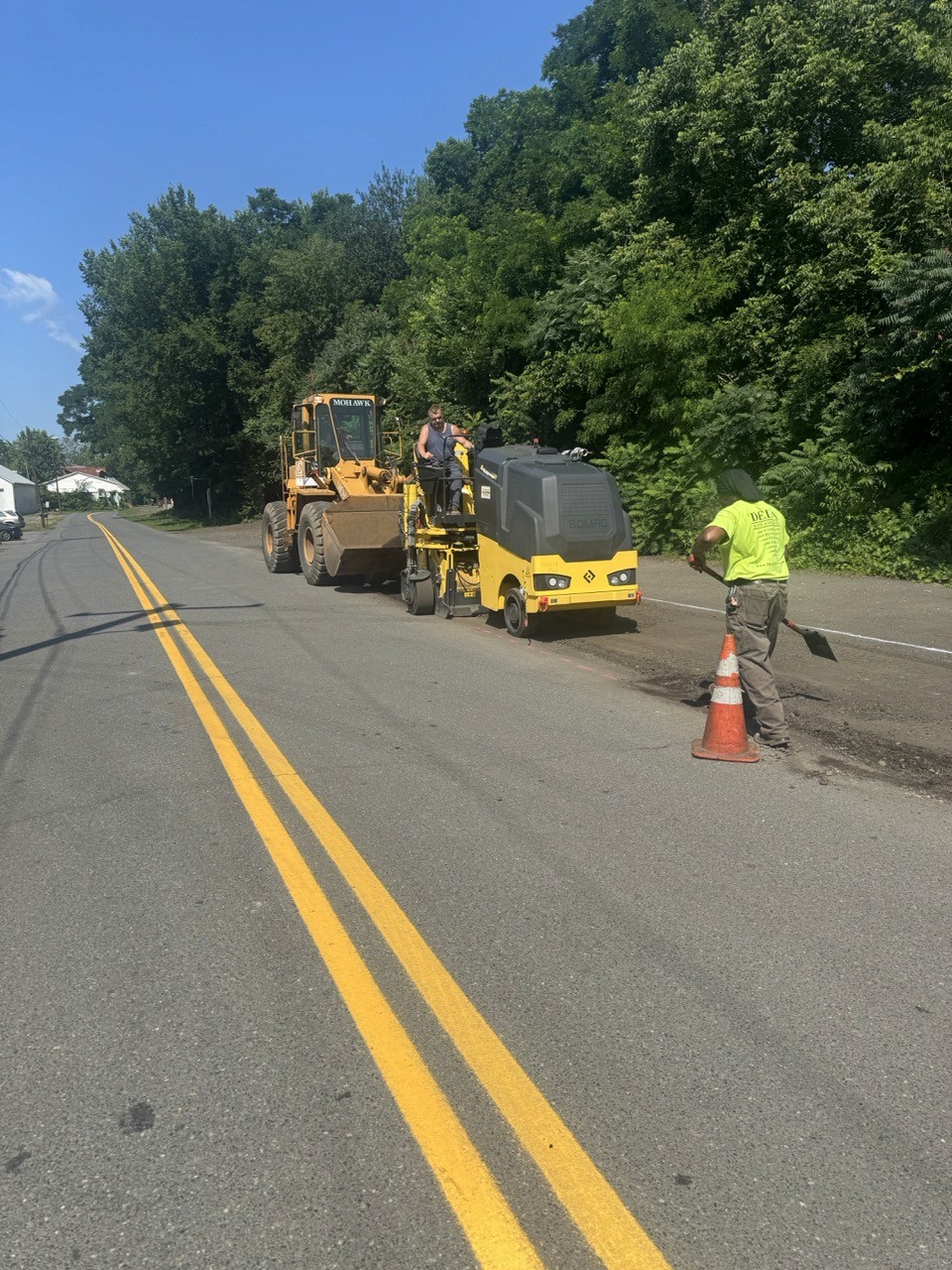 Roller and crew finishing a centerline trench patch