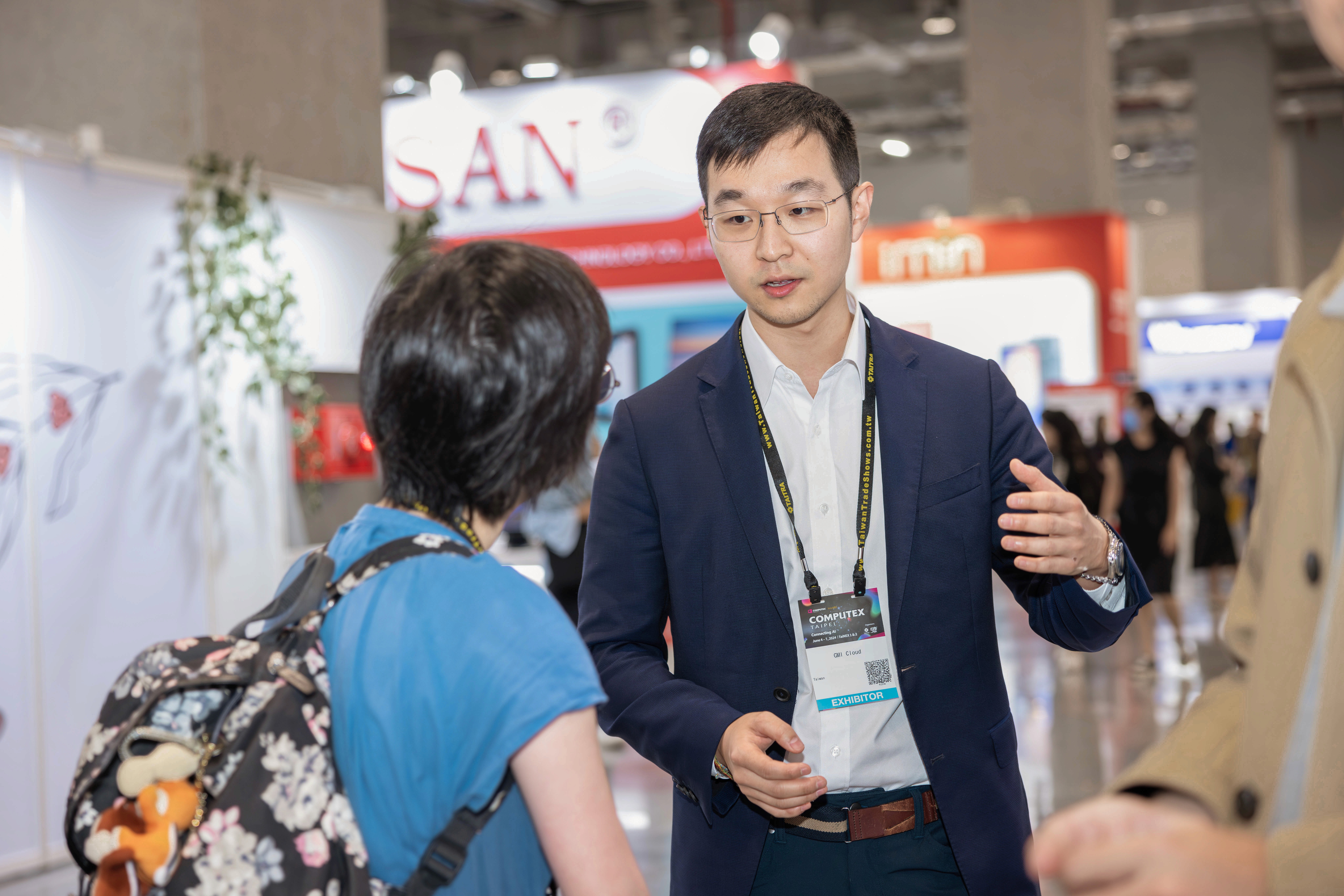 person discussing while standing in front of a large screen in front of people inside dim-lighted room
