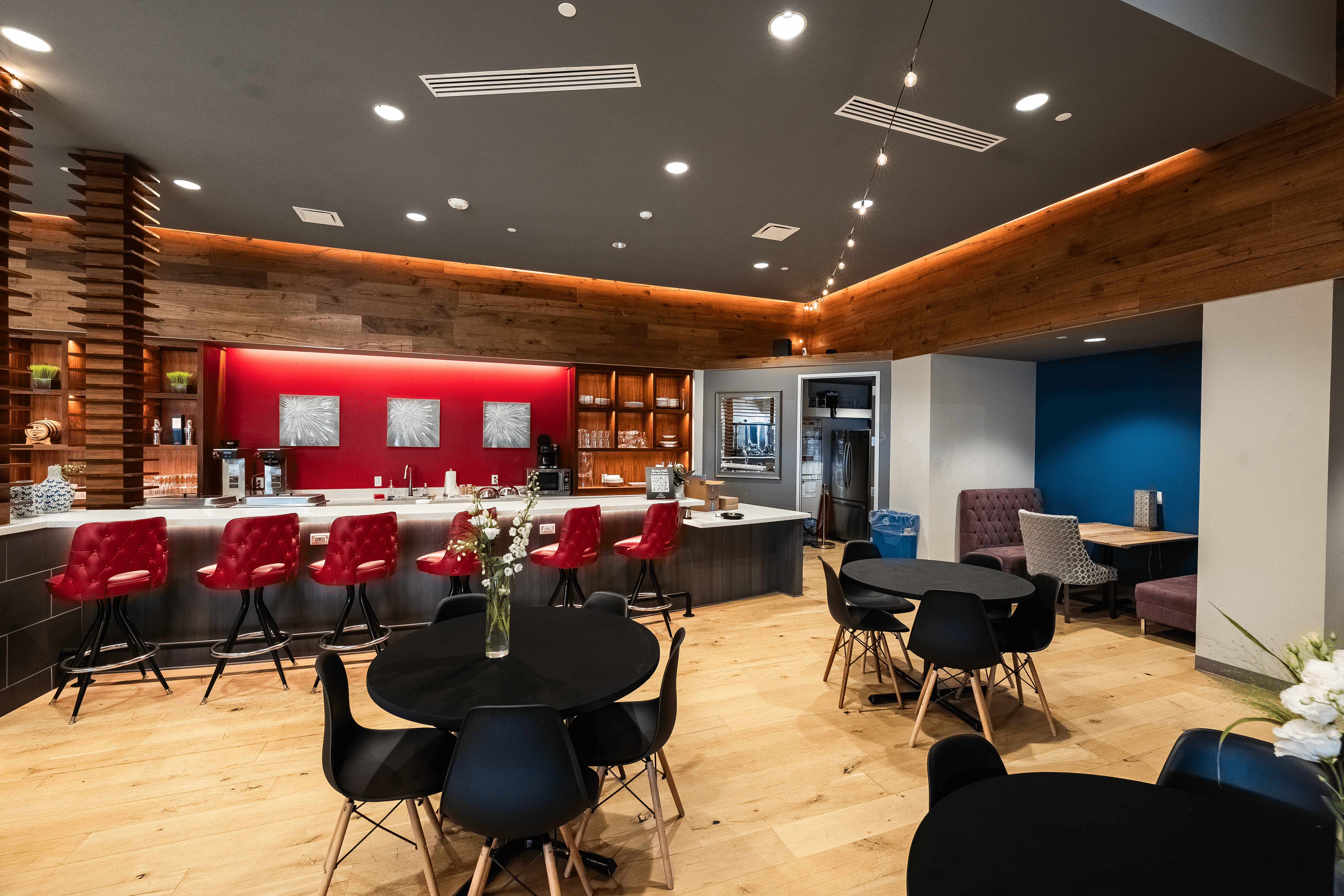 A winding road cuts through rocky terrain, surrounded by patches of green grass and illuminated by sunlight.