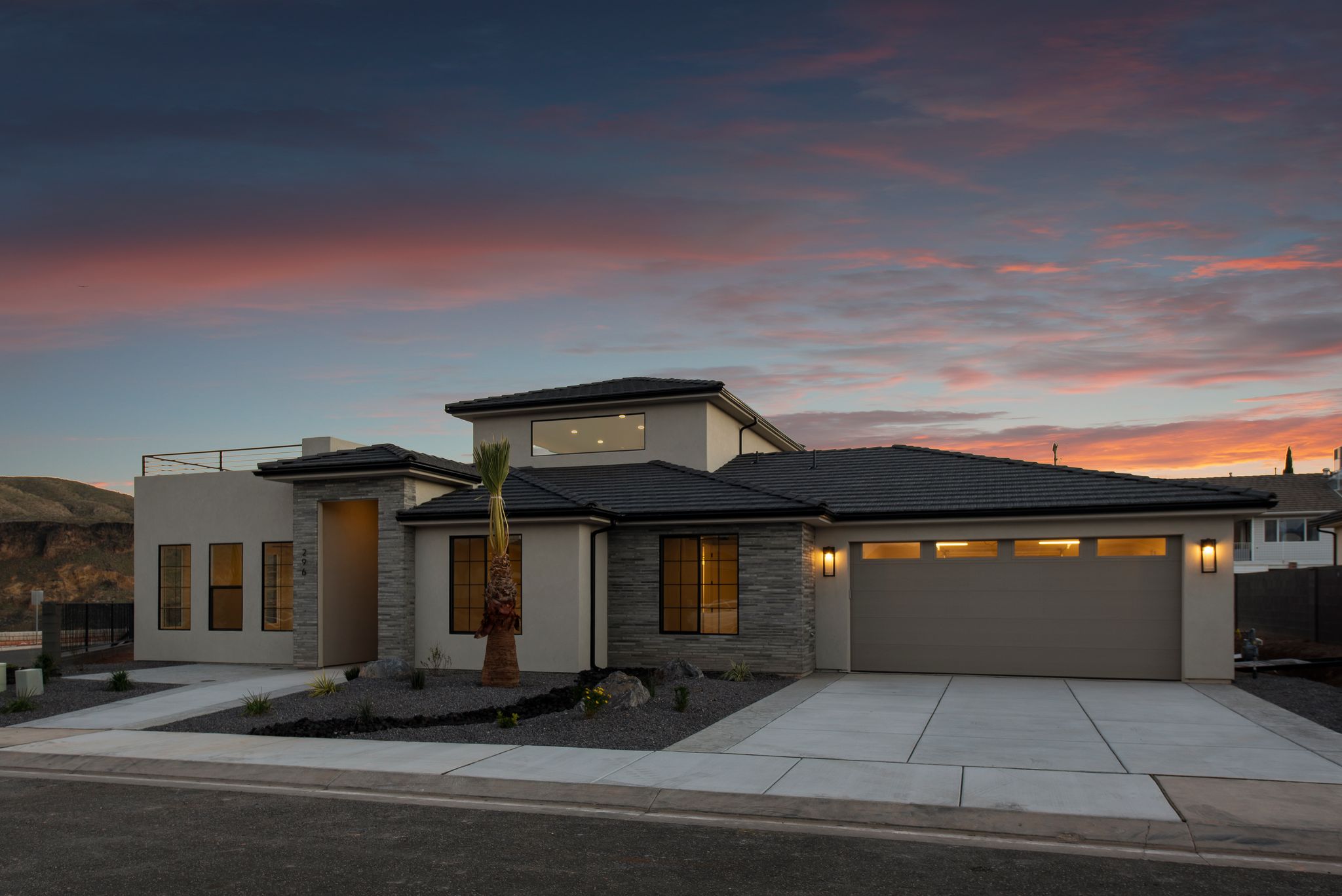 Nighttime exterior of The View at Falcon Ridge in Hurricane, Utah, showing illuminated windows and landscaping for dramatic curb appeal.