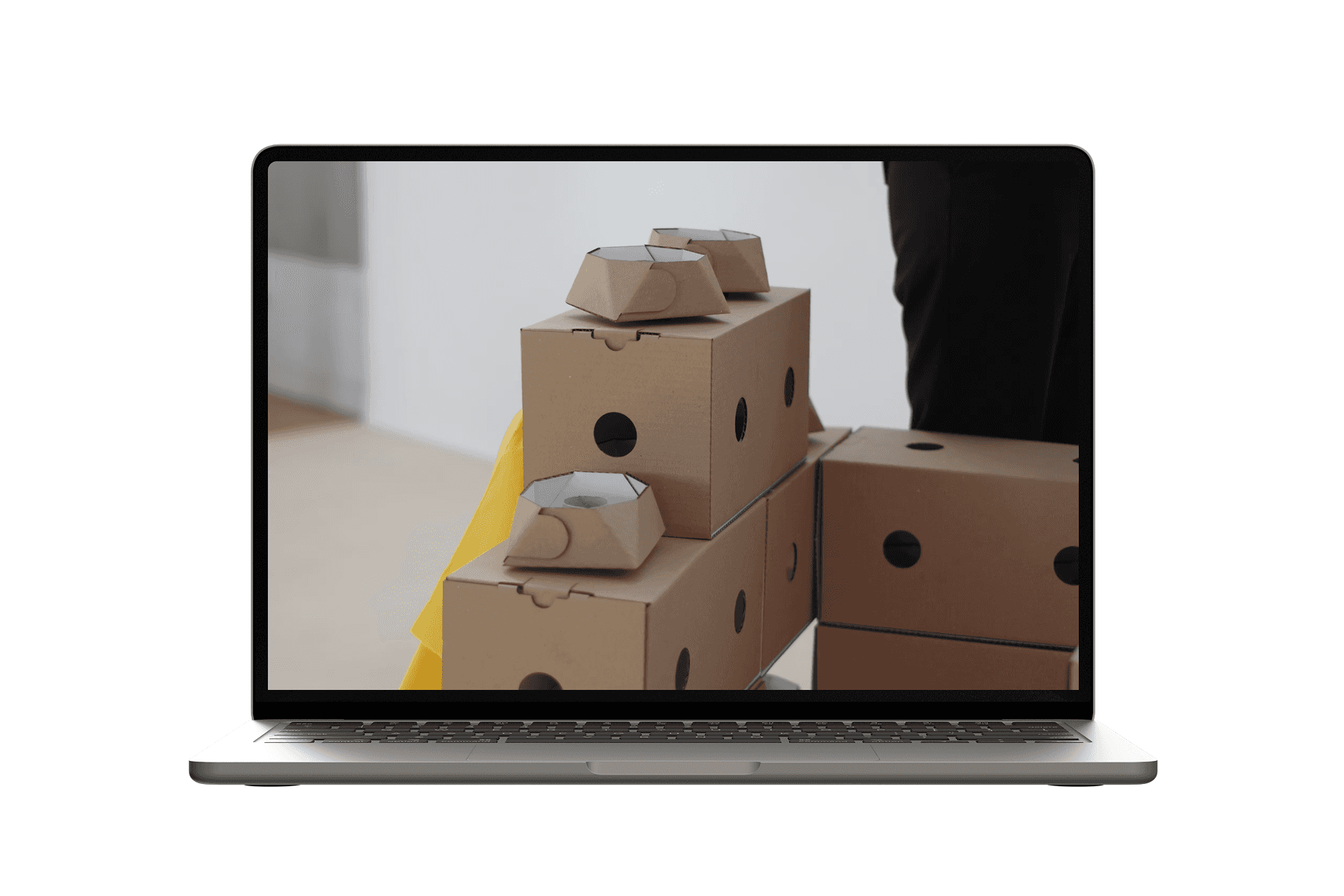 Laptop displaying modular cardboard packaging elements arranged as blocks.