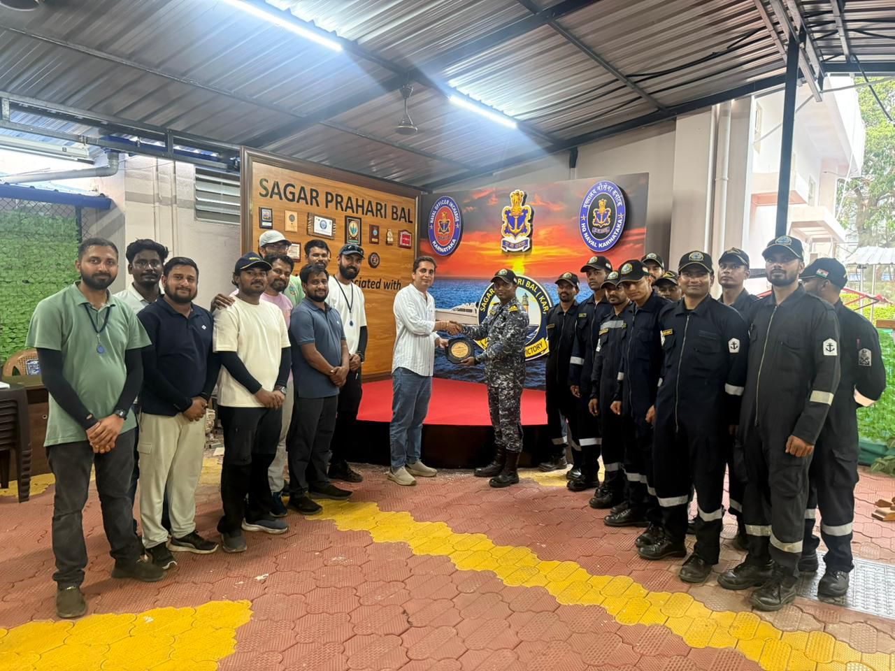 Group of students and staff gathered indoors during an organized institutional or industrial visit.