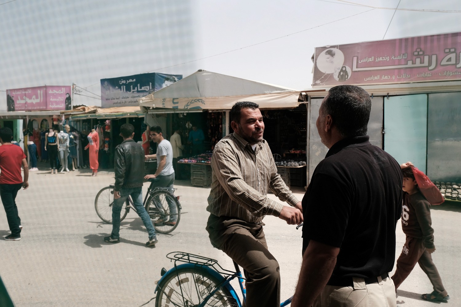 A refugee in Jordan's Zaatari camp talking to a community police assistant