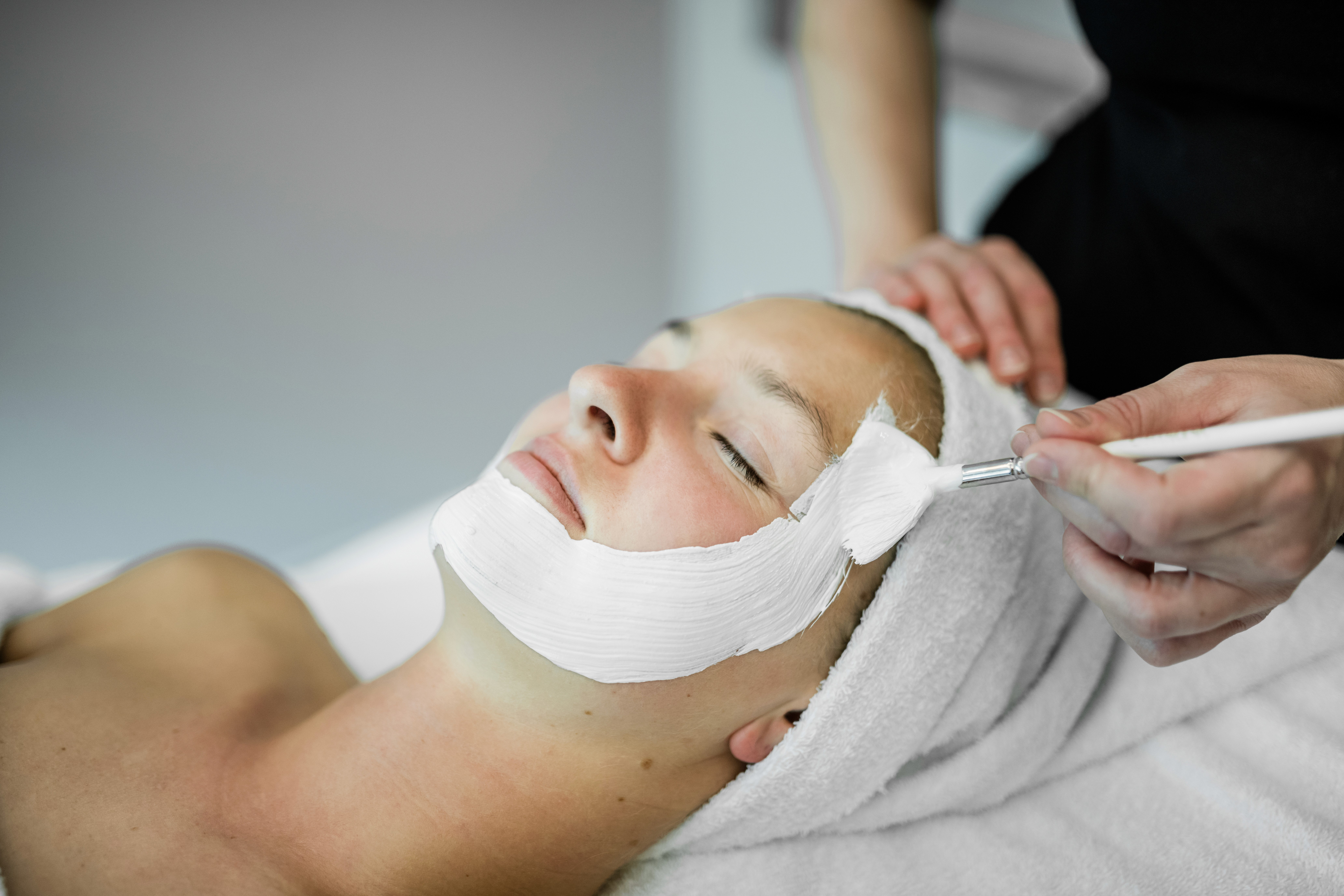 A sumptuous buffet spread features a variety of dishes including a bowl of sweet potato salad with feta and seeds, a mixed green salad with croutons, thinly sliced cured meats presented elegantly, and a vibrant antipasto platter adorned with arugula and sliced peaches.