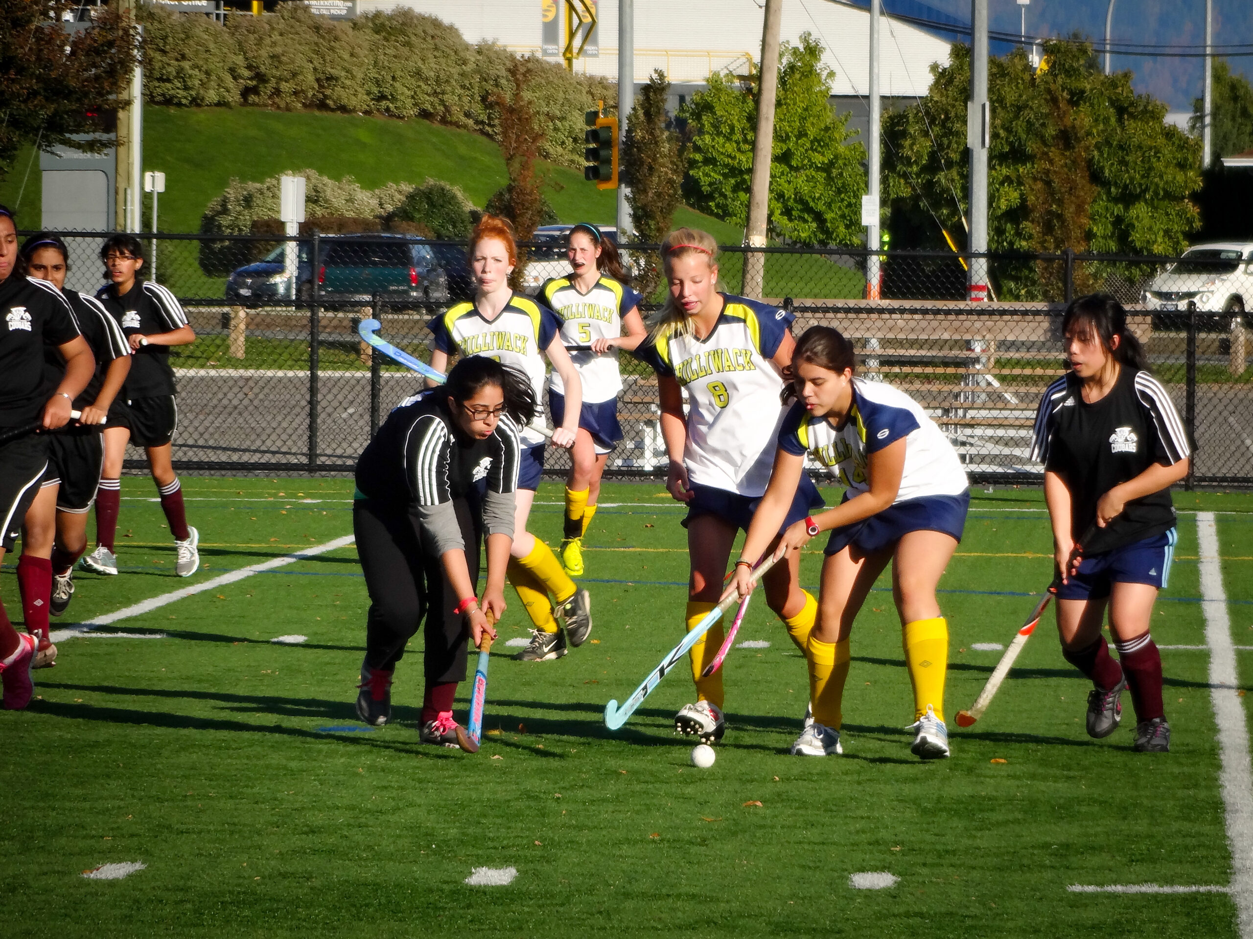 A multi-generational family poses for a group portrait outdoors.