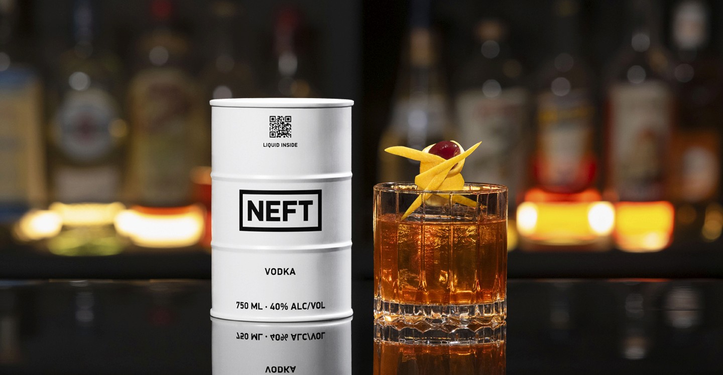 A NEFT Barrel and a glass of Prohibition Old Fashioned on a bar counter.