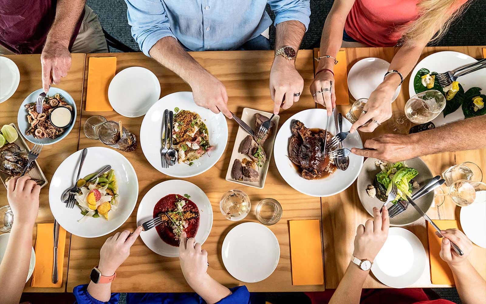 Gourmet dishes being shared at a communal table during a 3.5-hour lunch or dinner art tour.