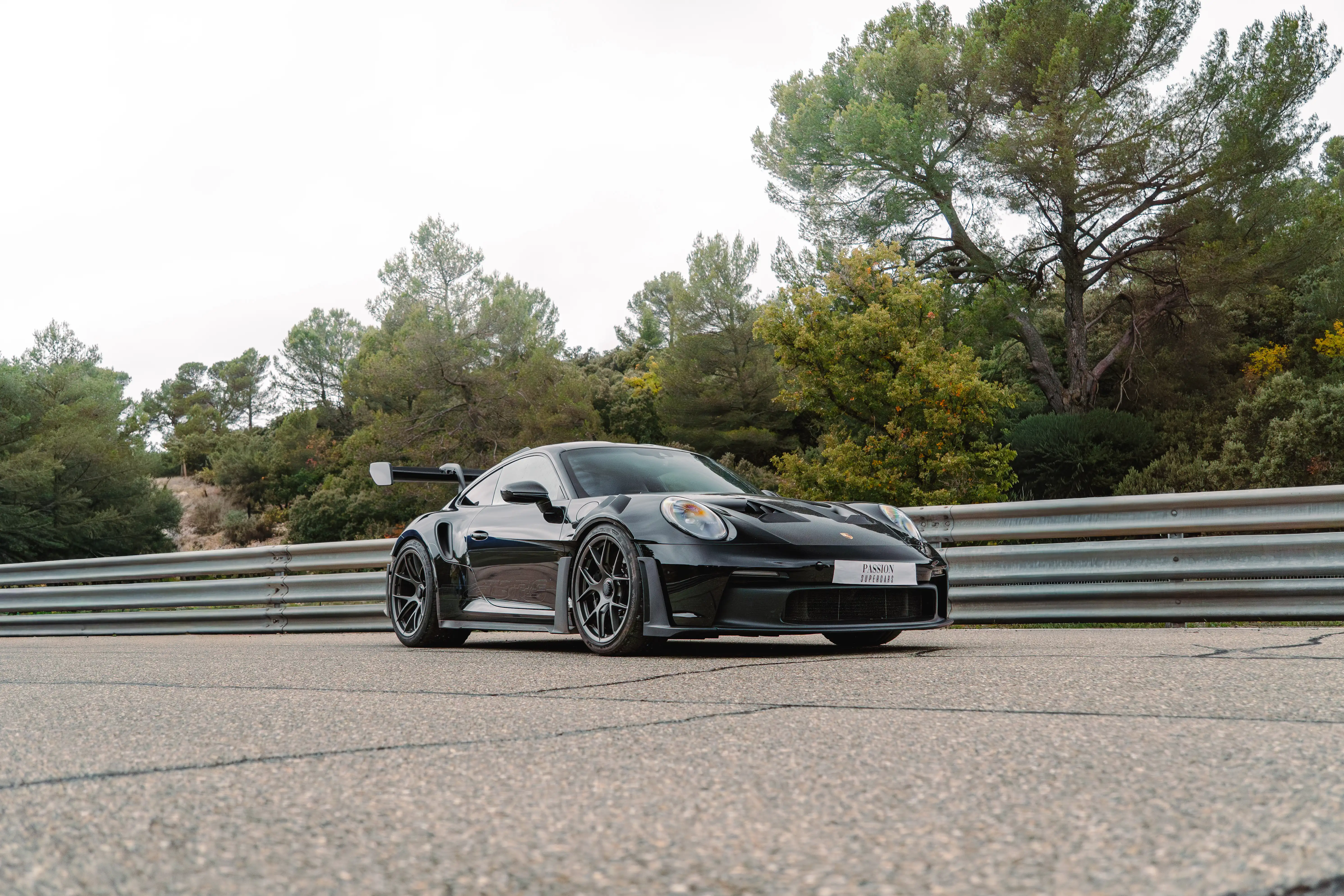 A person wearing a blue denim hoodie partially covers their face, revealing only their eyes with a focused gaze.