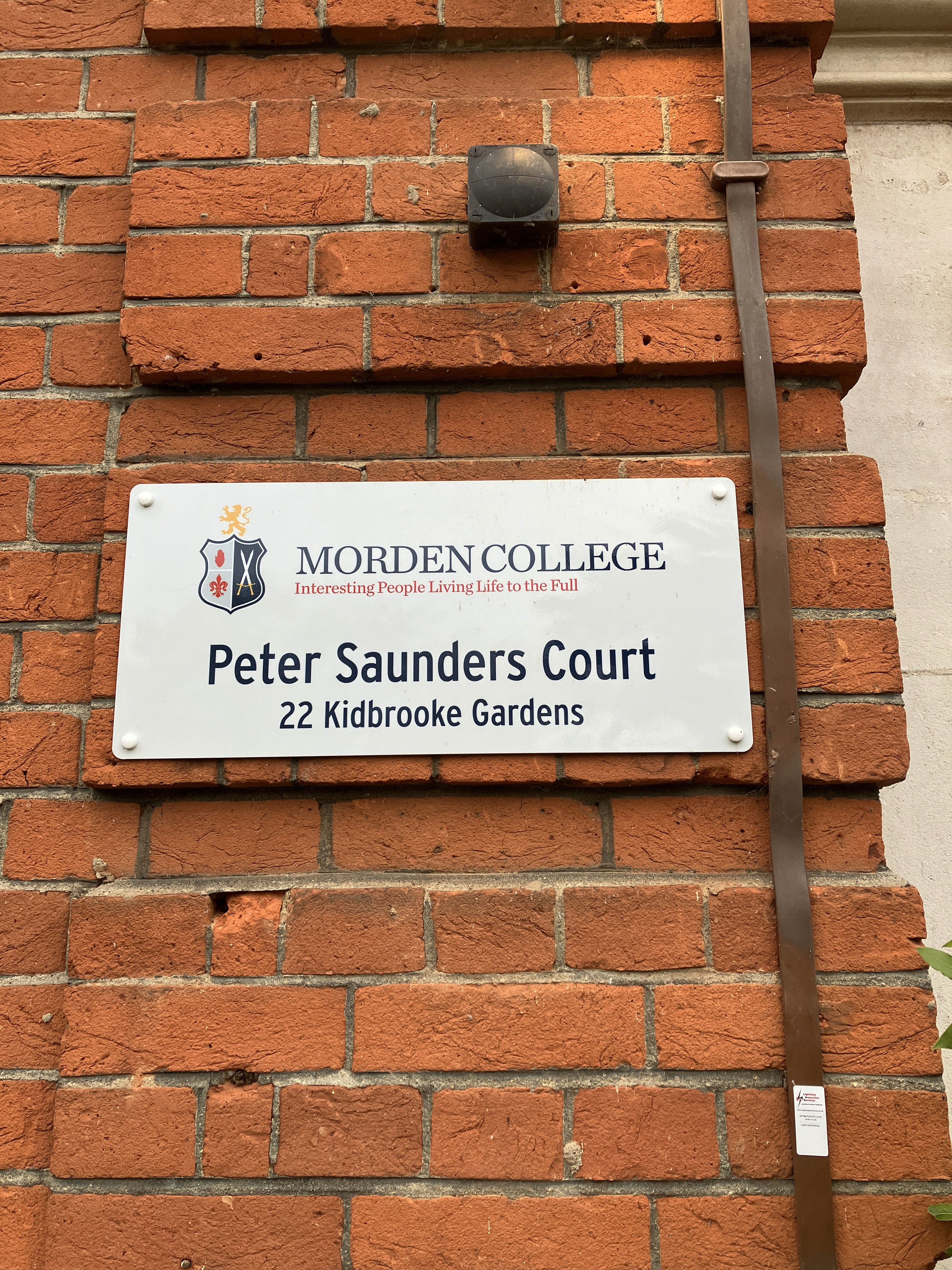 A group of construction workers wearing high-visibility jackets and hard hats celebrate at a construction site with safety signs and equipment visible in the background.