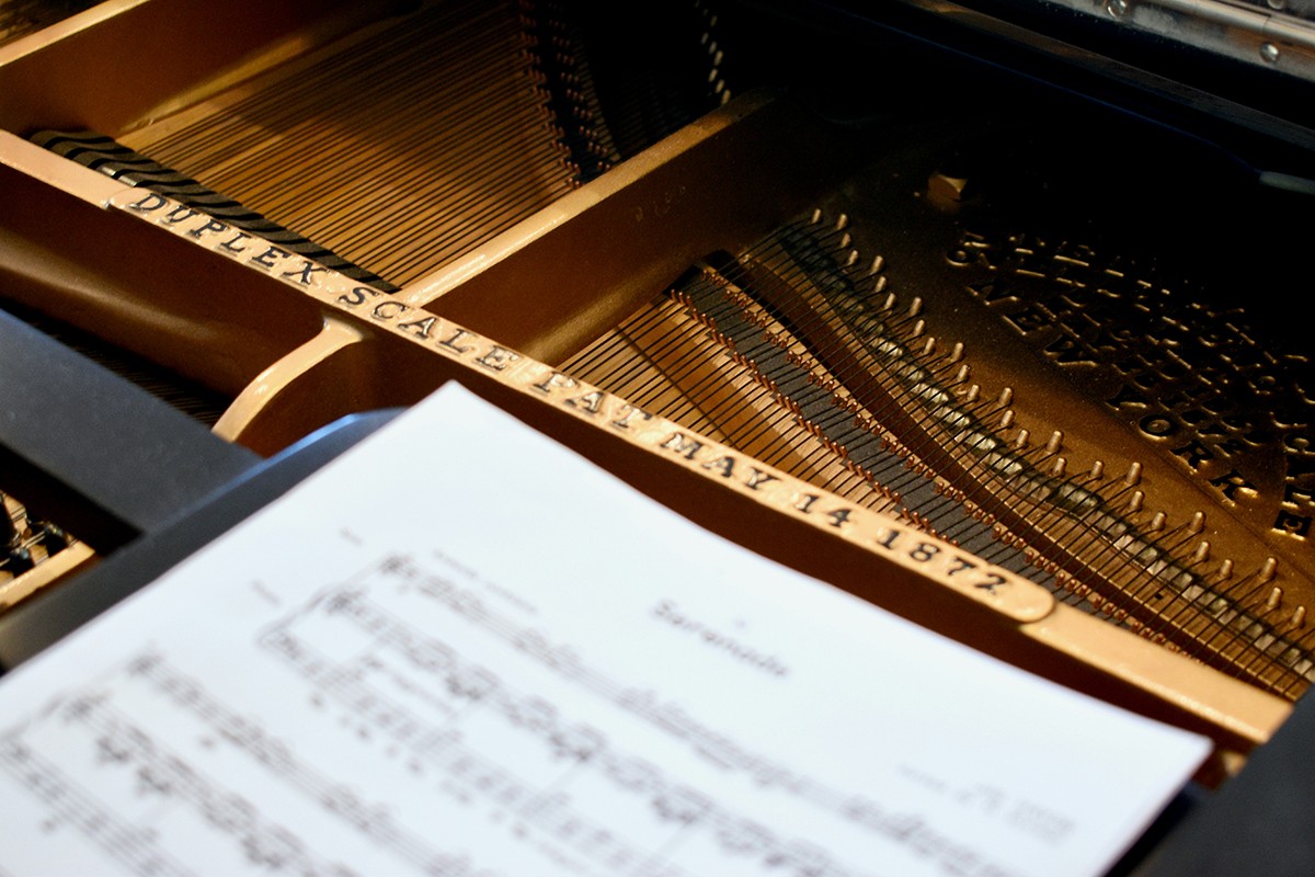 Close-up of a piano and sheet music, ready for a musical performance.