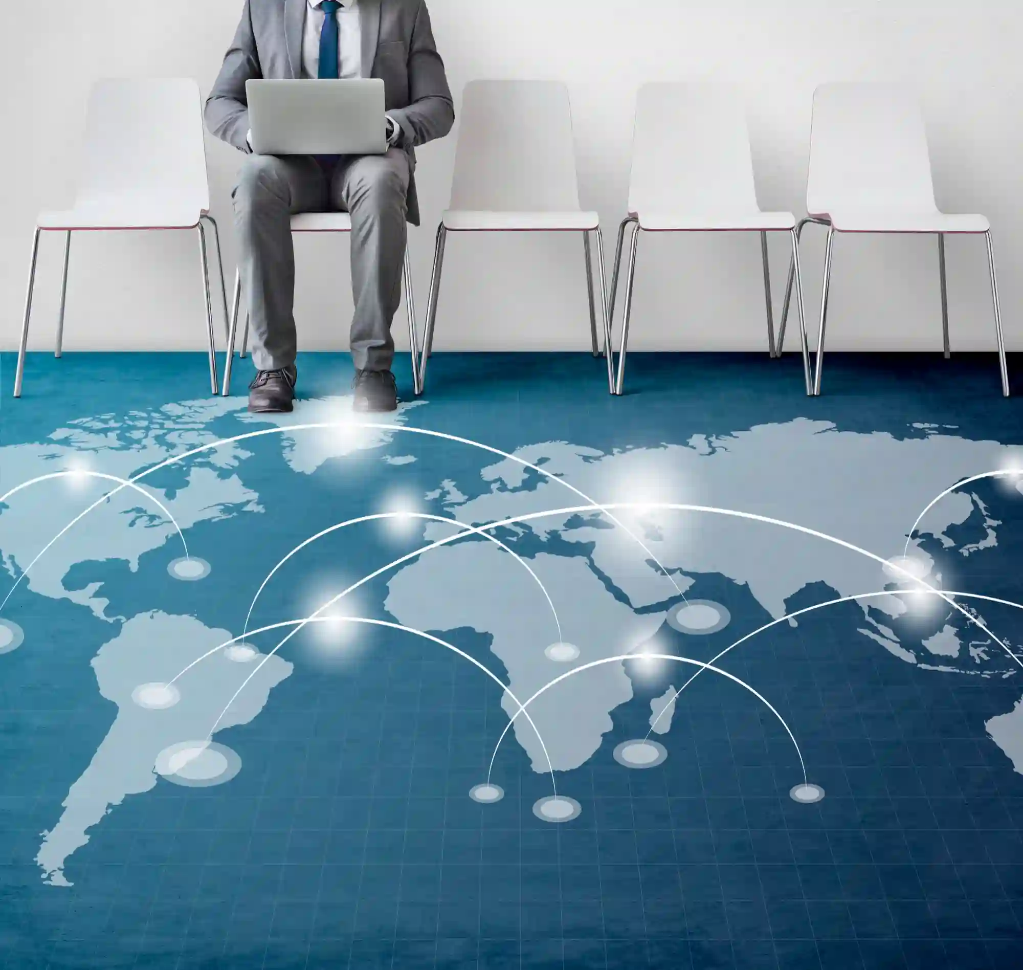 A businessman on a laptop above a glowing world map, illustrating the global connectivity and risks of international espionage.