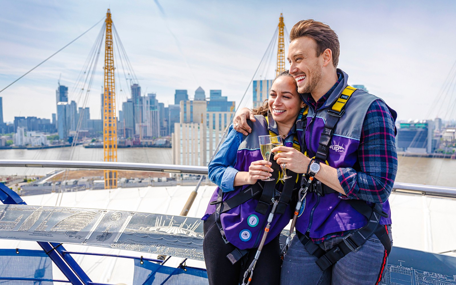 Guests enjoying drinks on Up at the O2 Celebration Climb with London skyline in background.