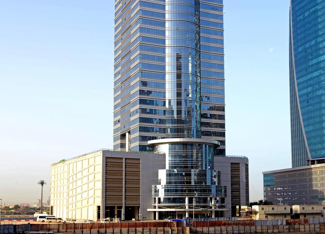 Full architectural view of a luxury office skyscraper available for sale or rent.