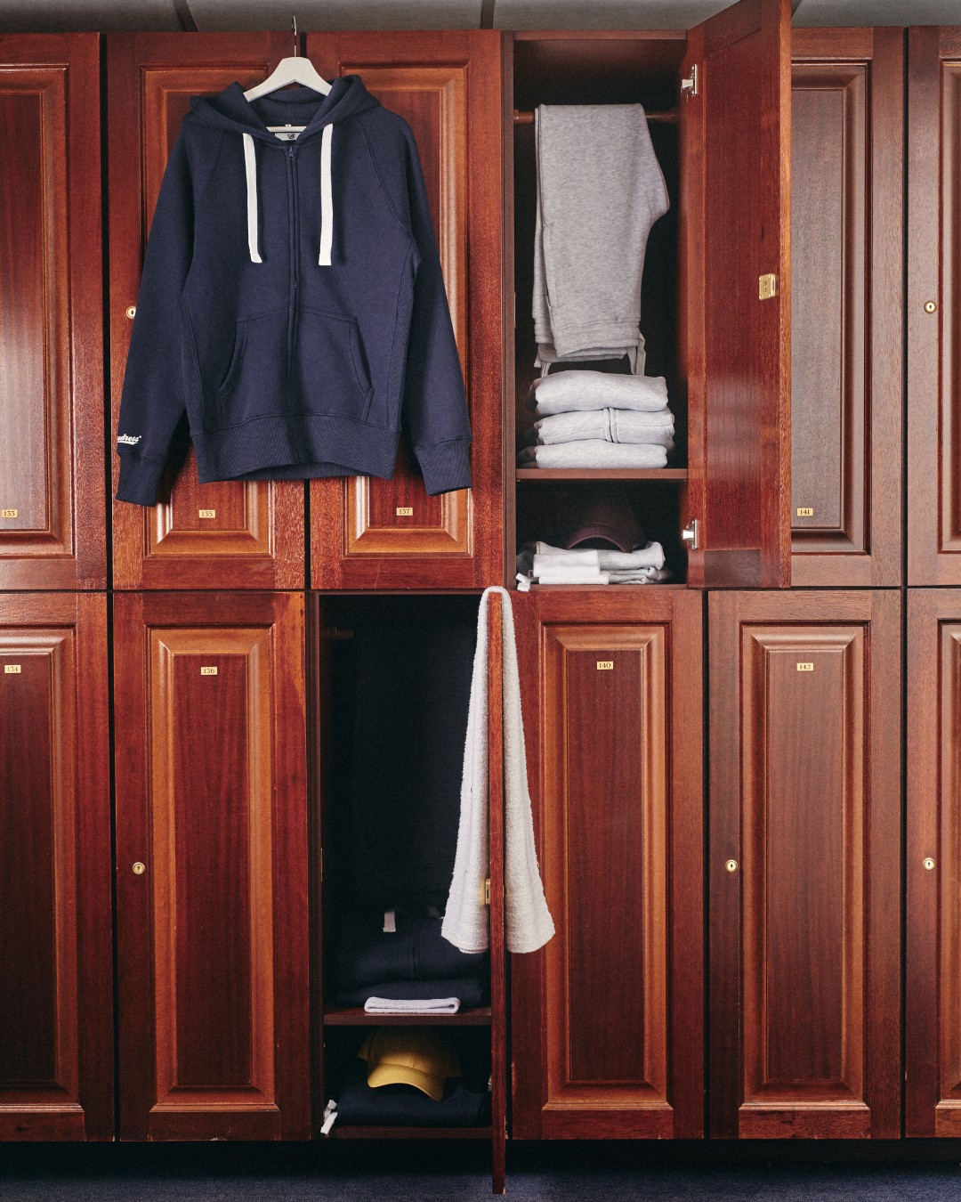 Russemerch garments inside and hanging on a retro wooden wardrobe setting