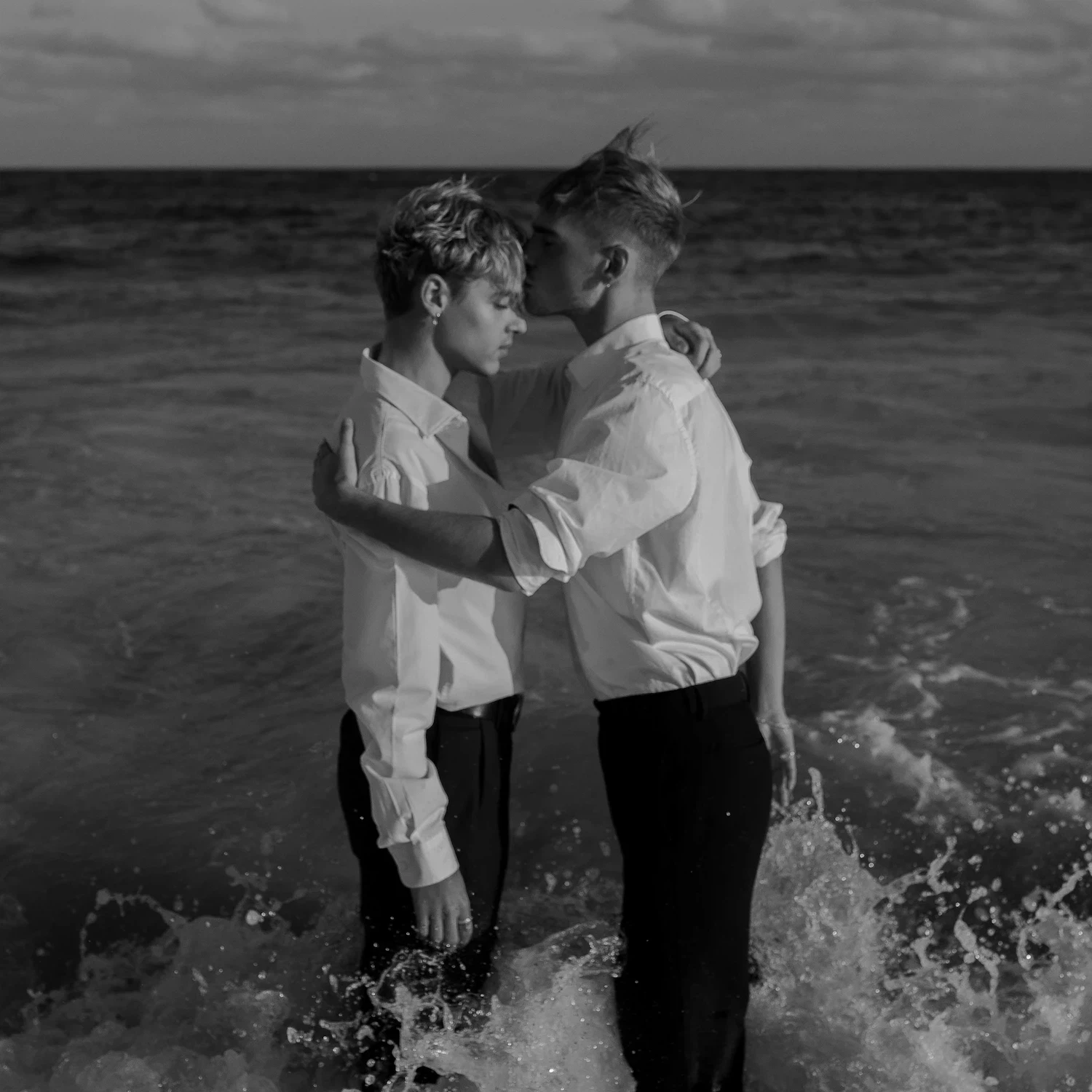 Couple embracing in the ocean symbolizing healing and emotional connection through LGBTQ codependency therapy and relationship counseling.