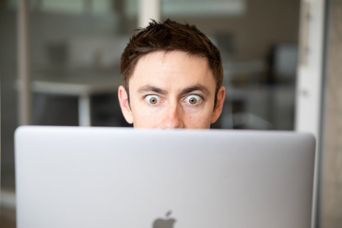 man looking in shock at computer screen after realizing how expensive SEO can be