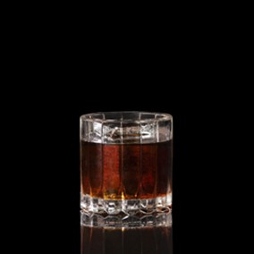 A closeup of a Black Russian drink against a dark background.
