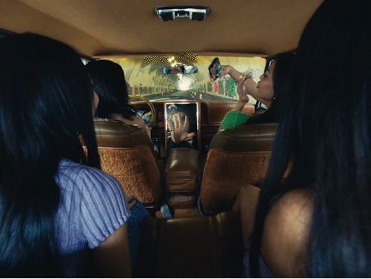 A person walks down a dimly lit alley at night.