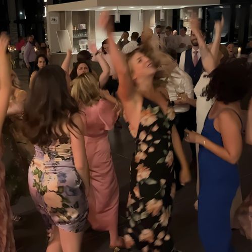 Couple dancing joyfully at their wedding reception in Collingwood, with friends and family celebrating around them.